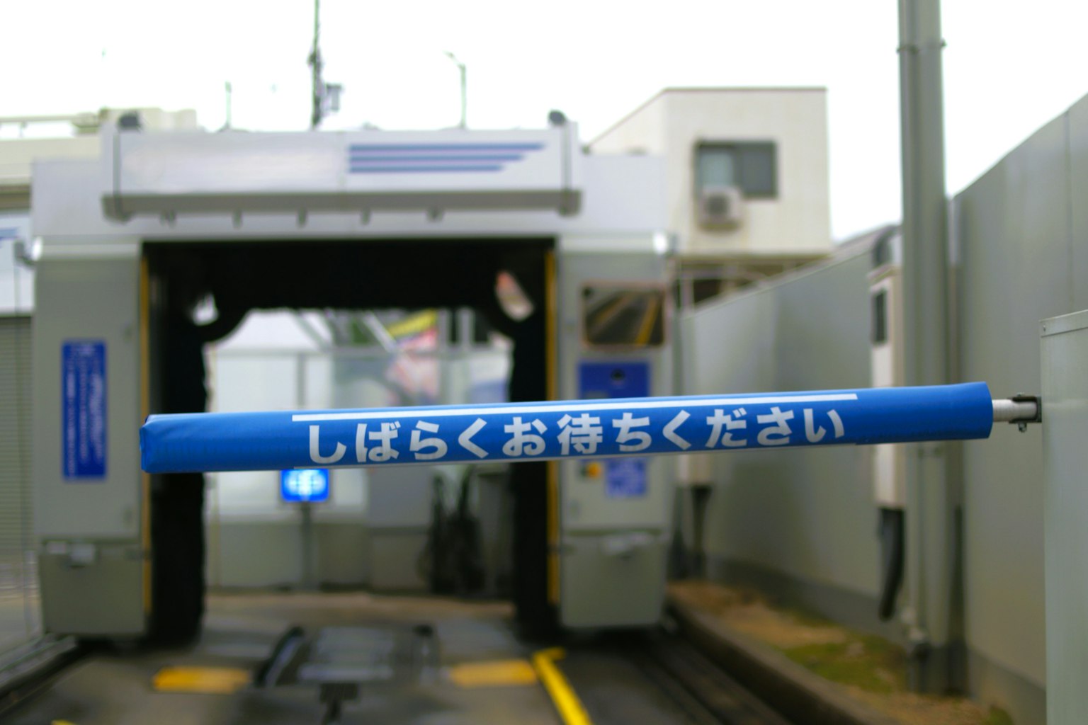 洗車場入口的藍色障礙桿上方有日文說明
