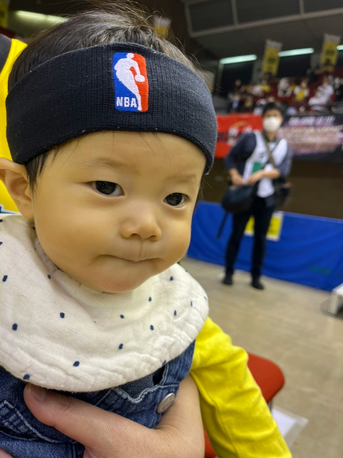 NBAロゴの帽子をかぶった赤ちゃんの見つめる表情