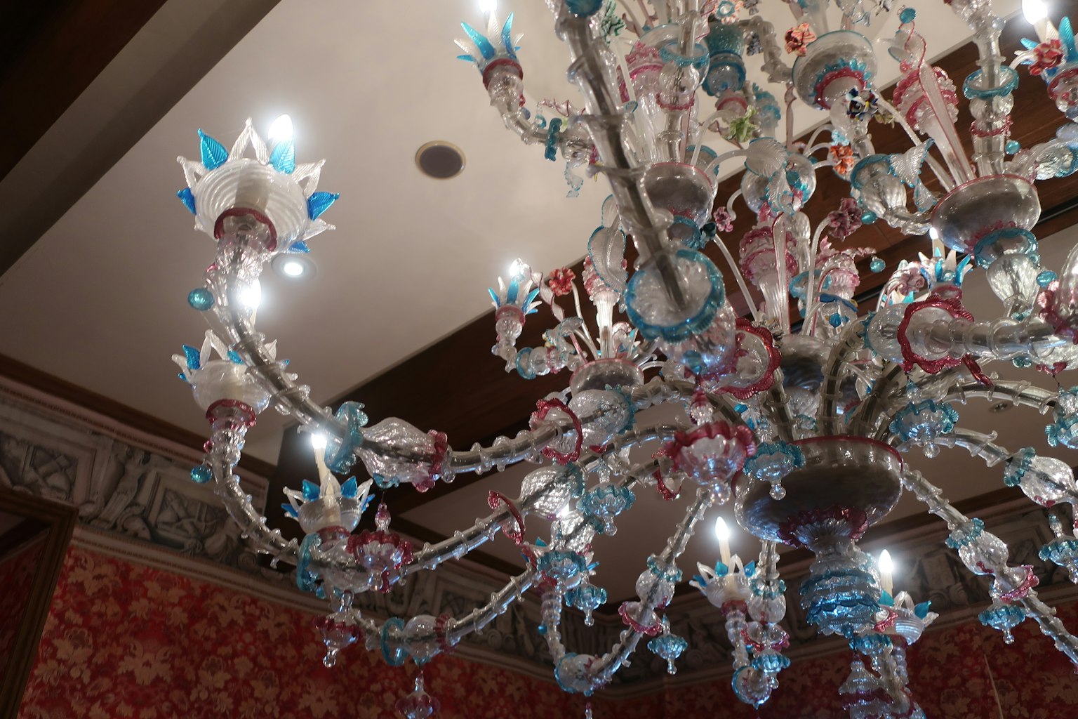 Bild zeigt einen bunten Kronleuchter mit blauen und rosa Elementen