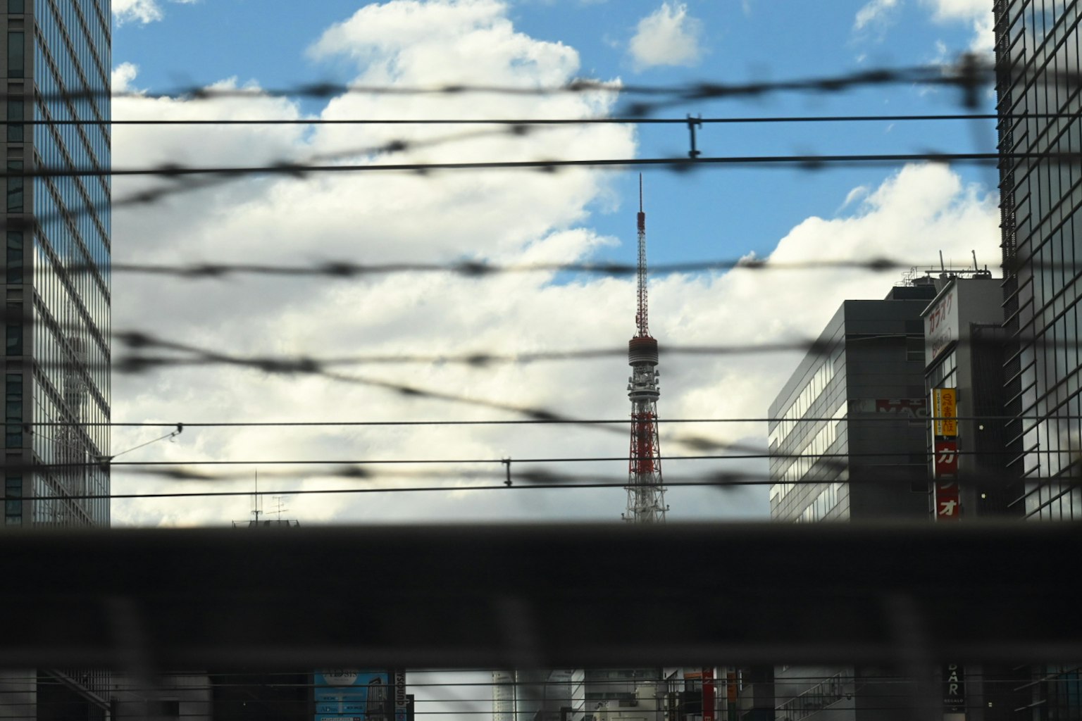 Paesaggio urbano con la Torre di Tokyo visibile attraverso il filo spinato