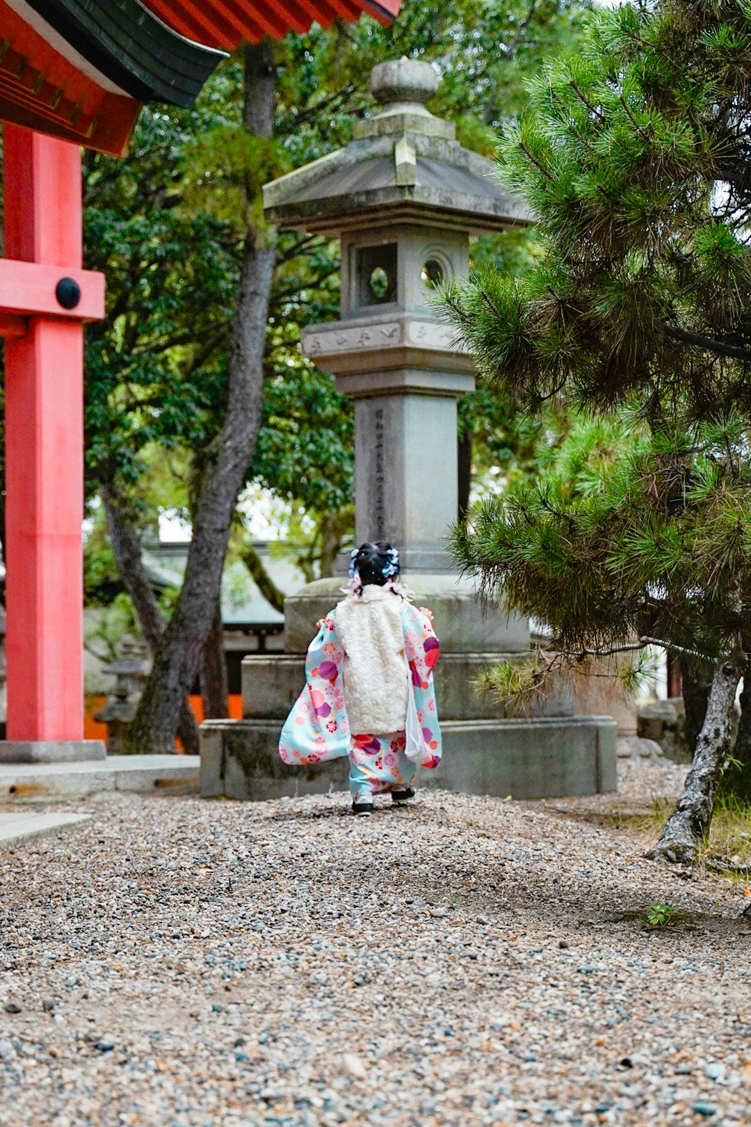 朱塗りの門と石灯籠のある神社の参道