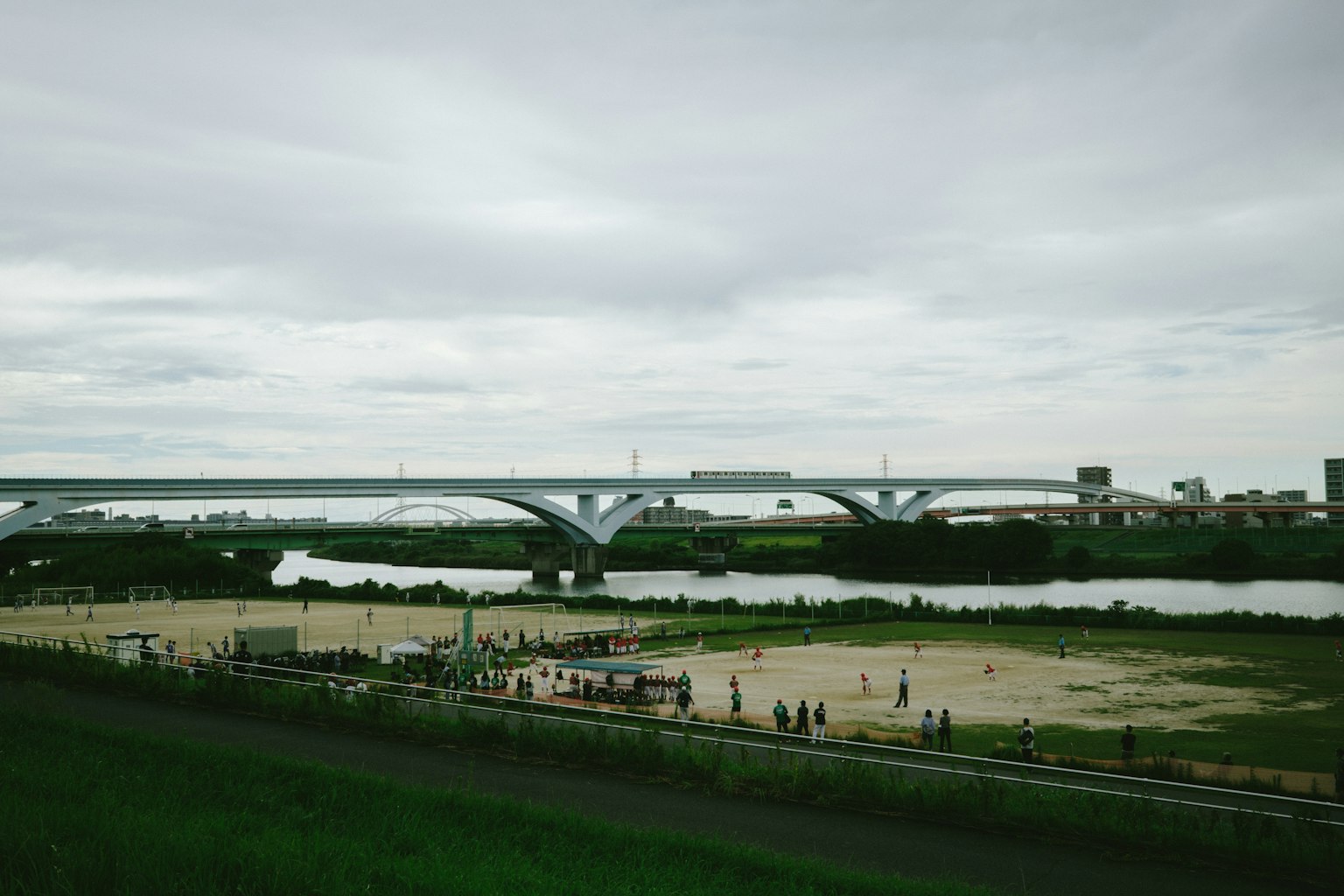 Paesaggio con un ponte sul fiume e persone