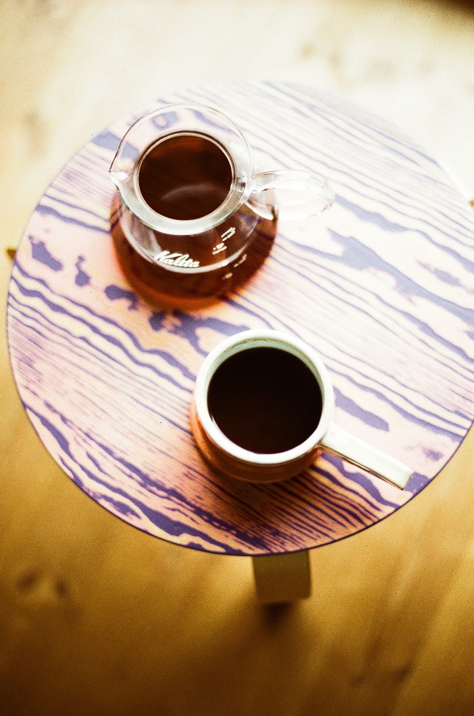 กาแฟและถ้วยบนโต๊ะไม้สีม่วง