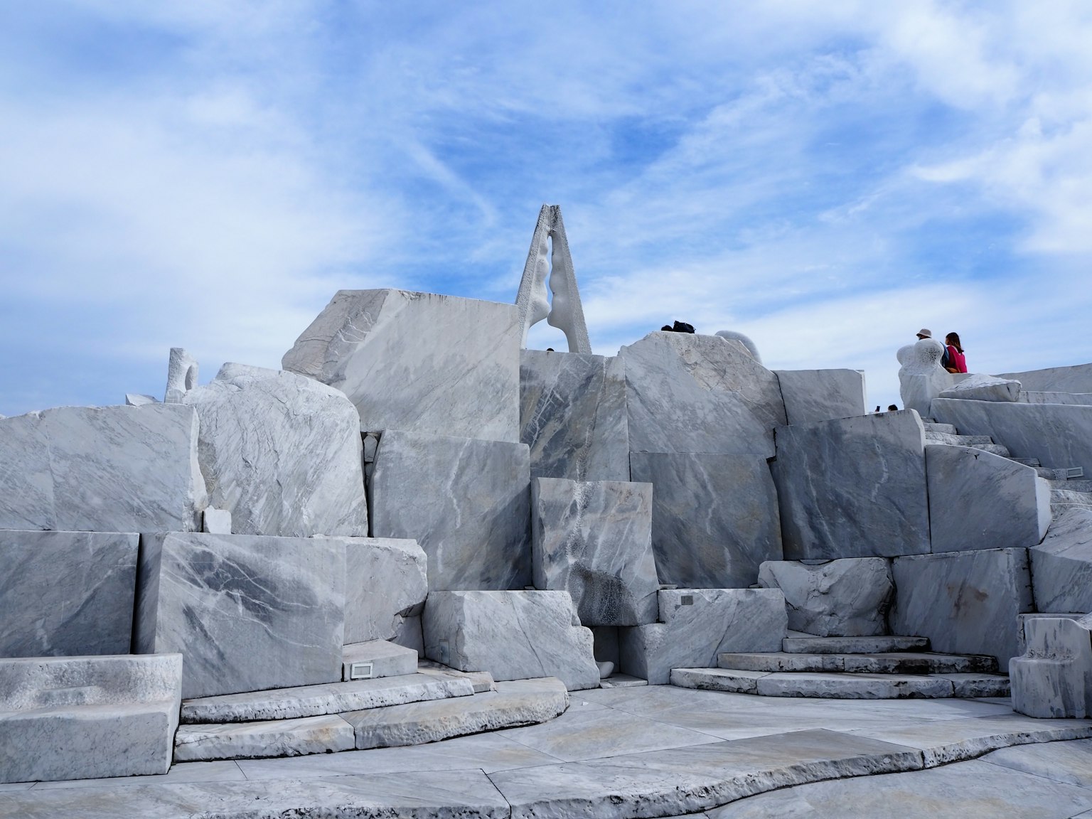 Composizione di sculture in marmo con strutture in pietra contro un cielo blu