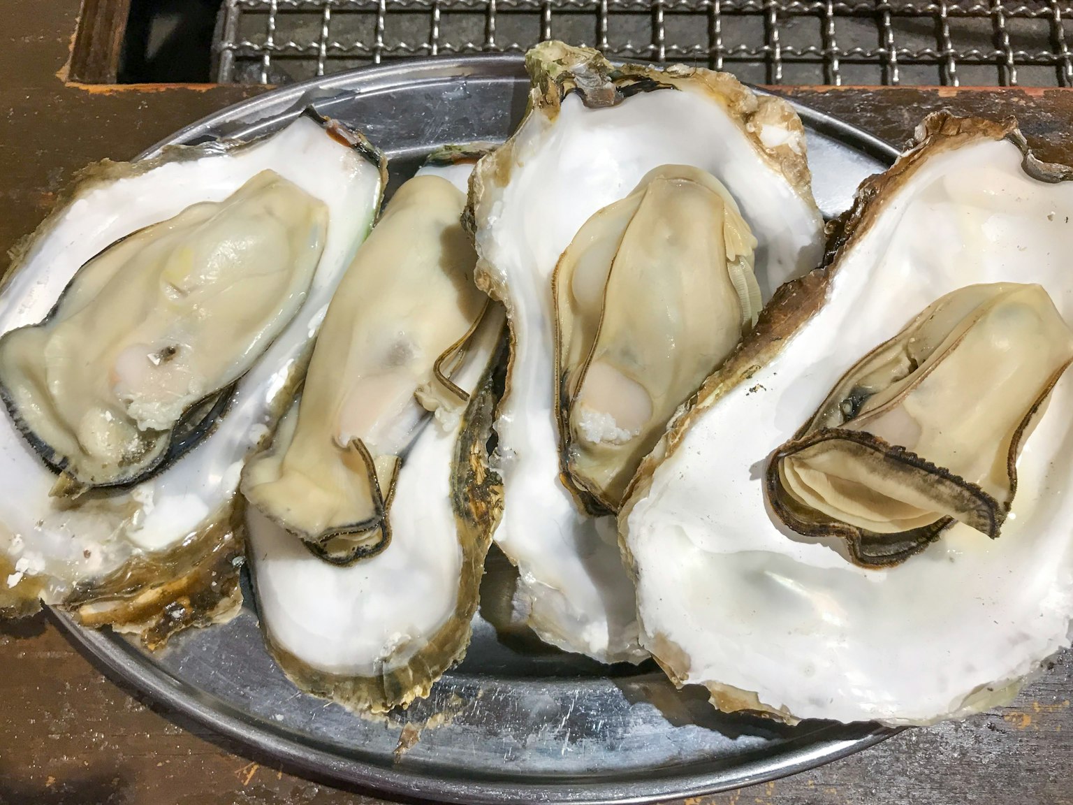 Fresh oysters displayed on a metal plate
