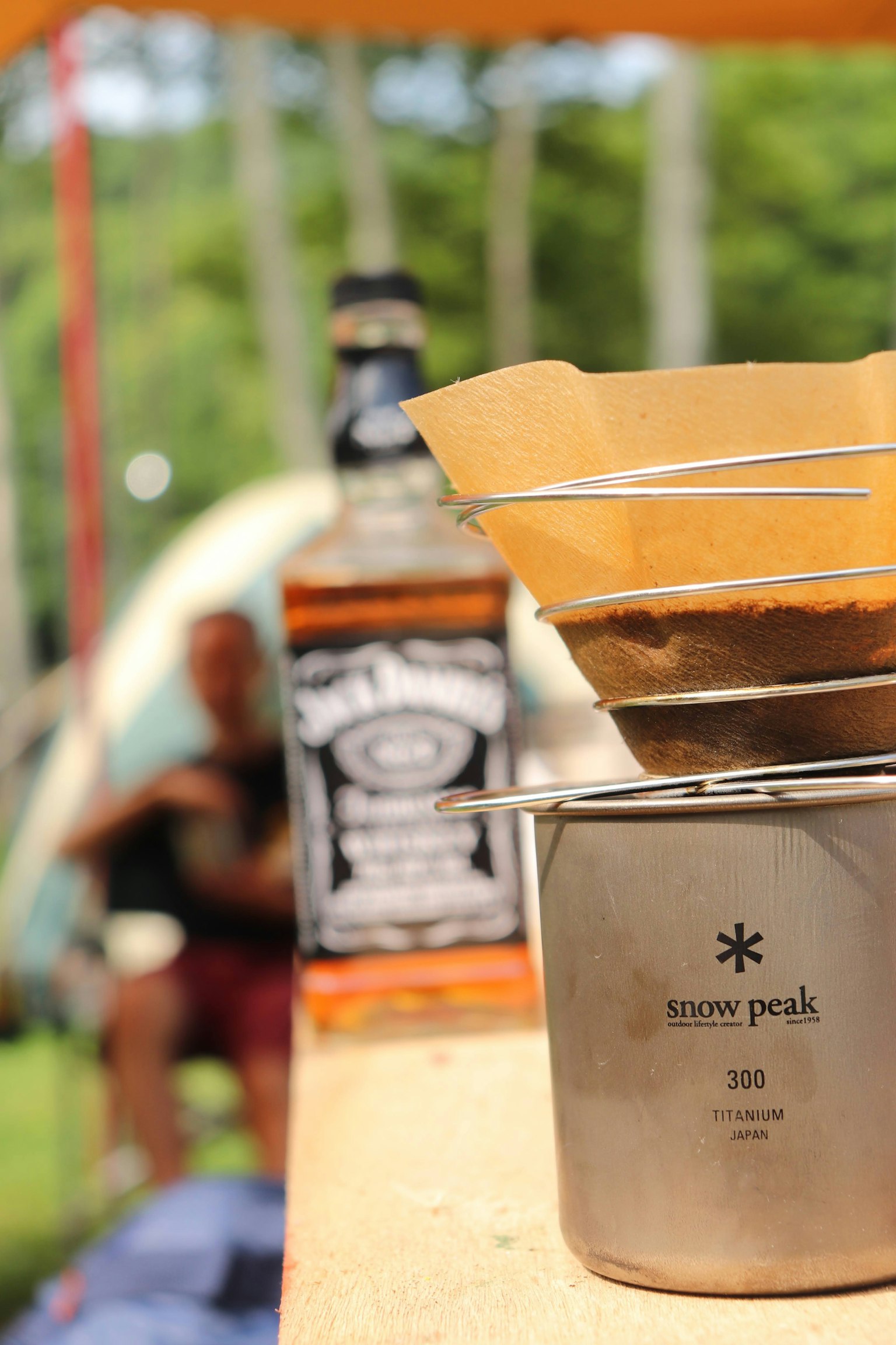 Penyaring kopi dan botol wiski di lingkungan perkemahan