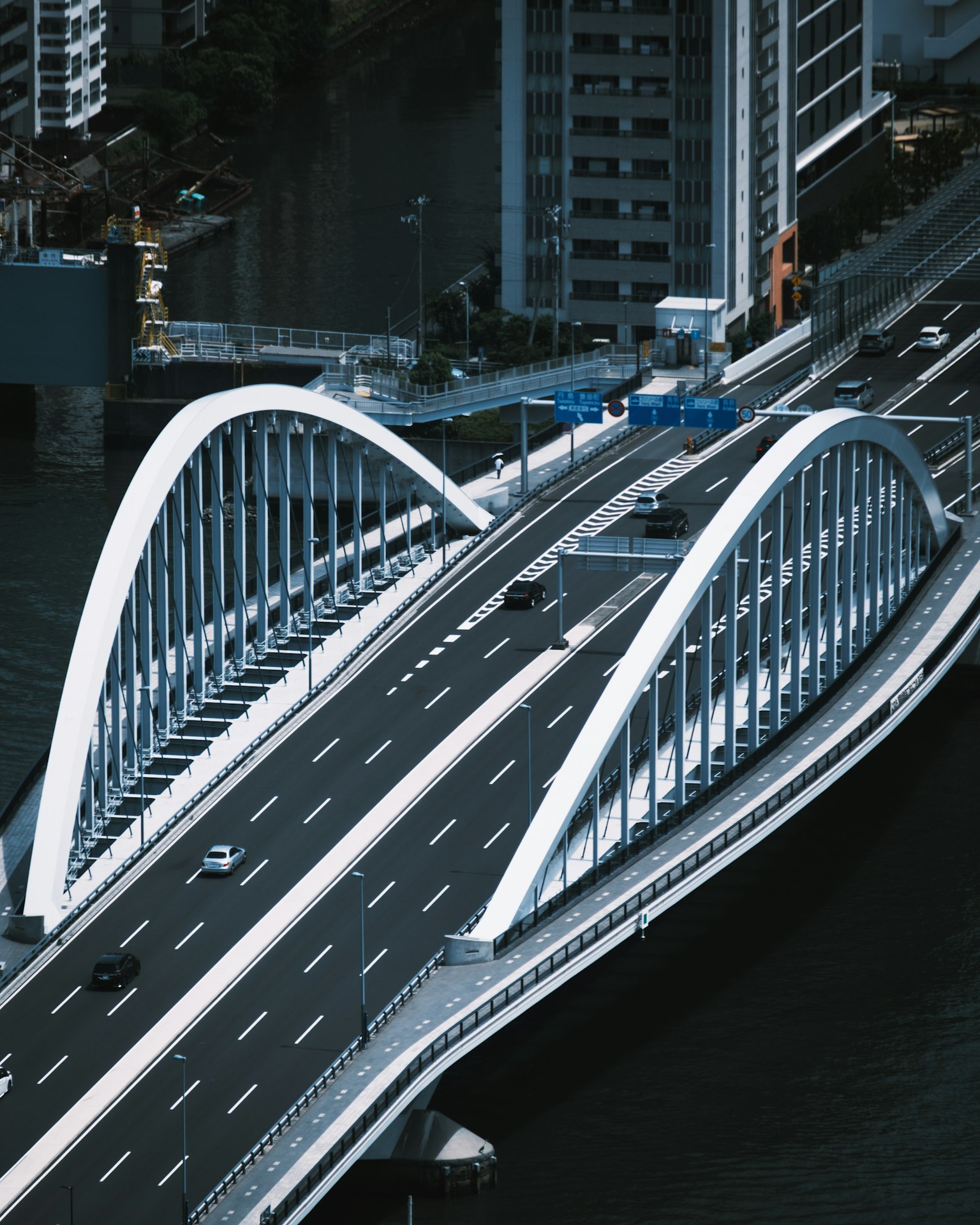 Jembatan lengkung modern dengan lalu lintas dan pemandangan kota