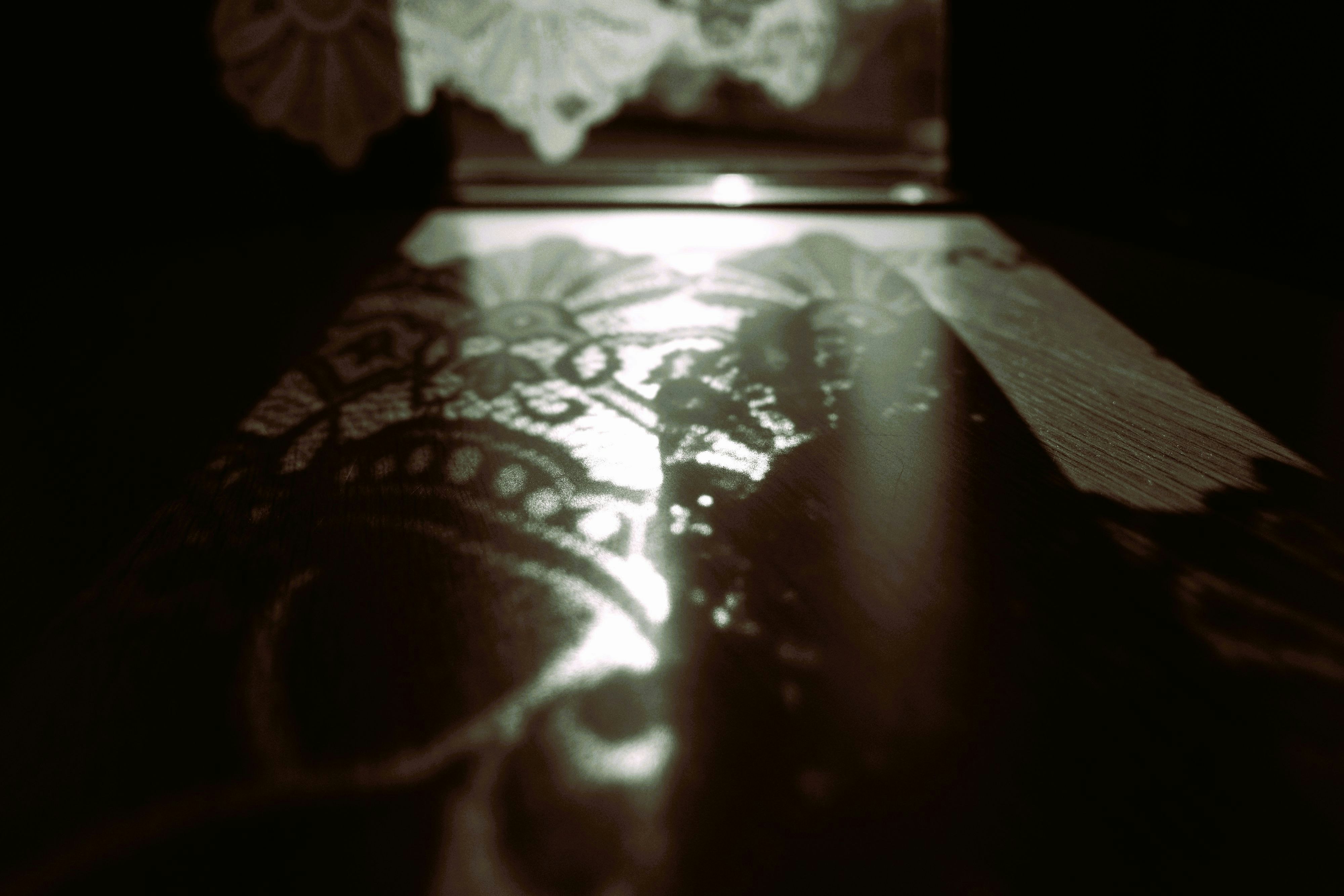 Lumière du soleil à travers une petite fenêtre et ombres du rideau en dentelle