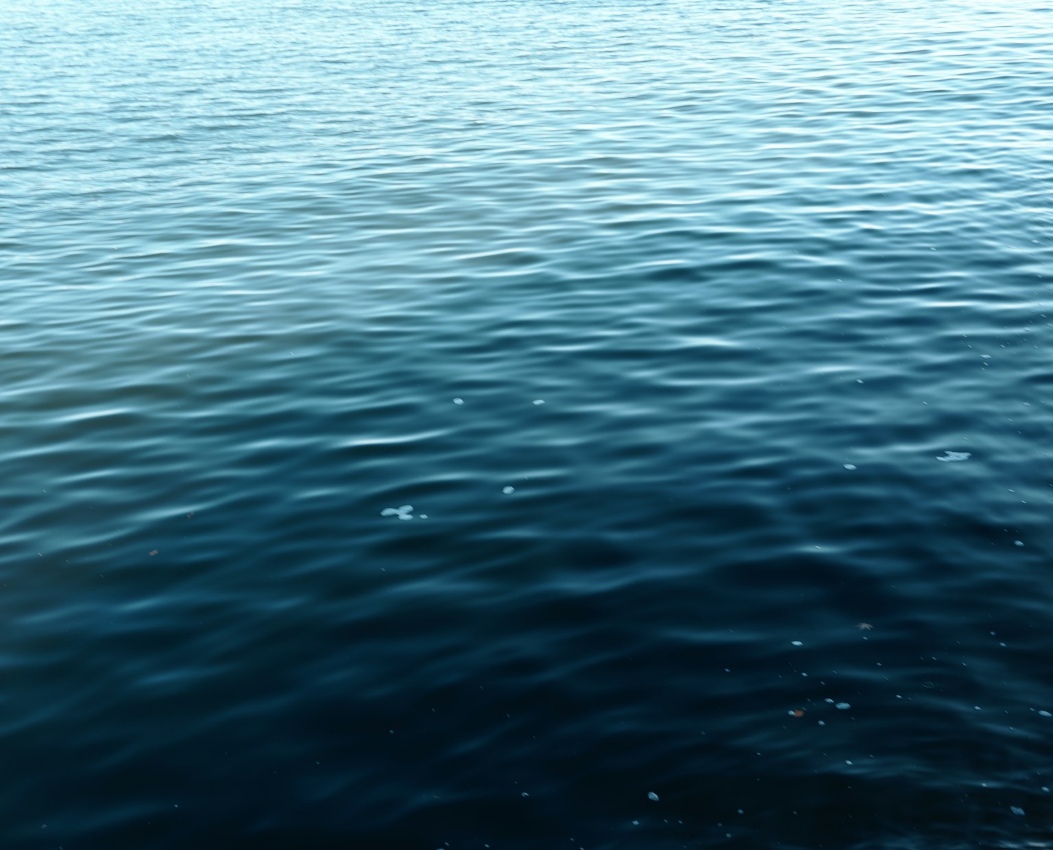 Calm water surface with ripples in deep blue hues