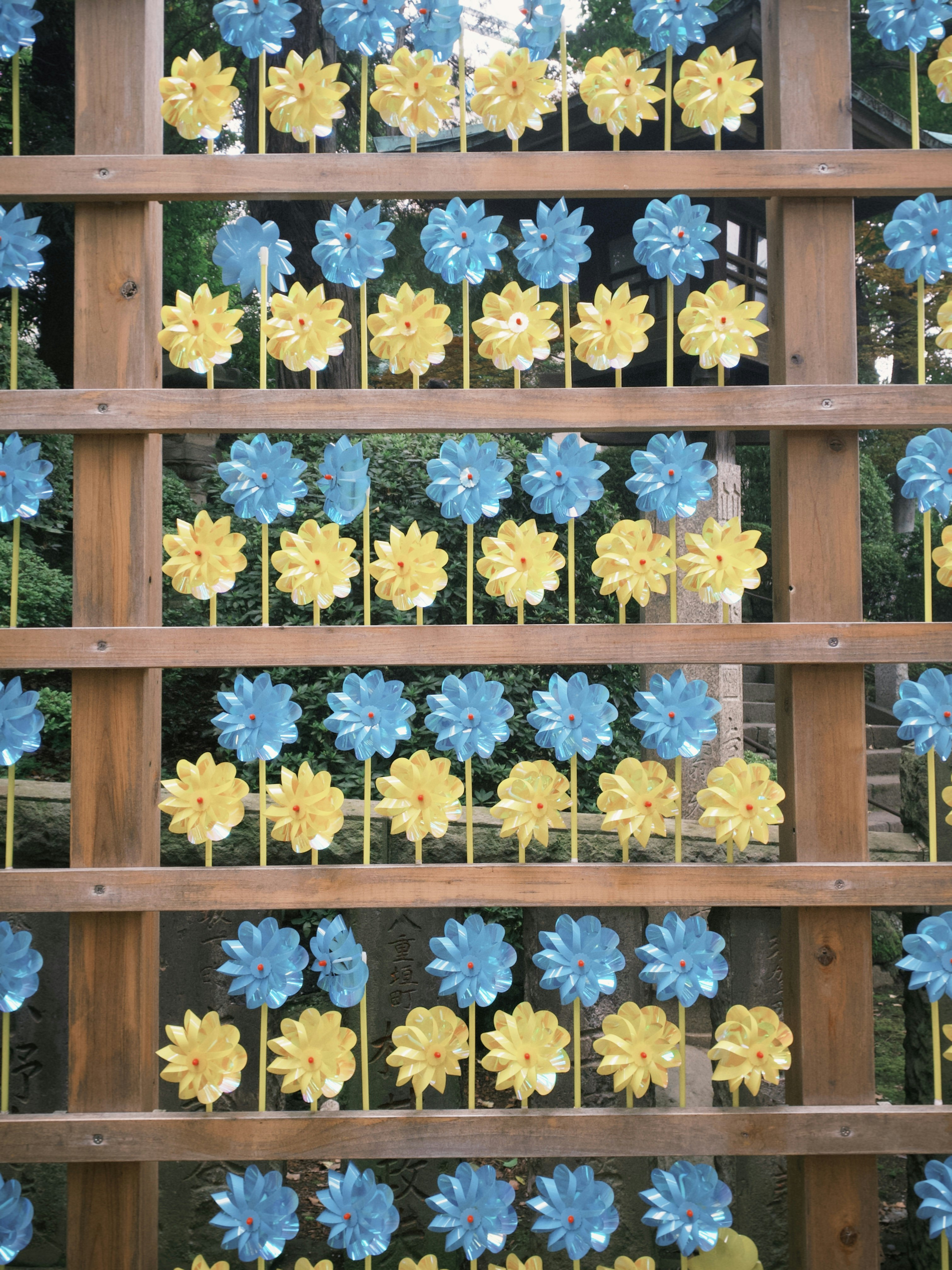 木製の格子に並ぶ青と黄色の花の装飾