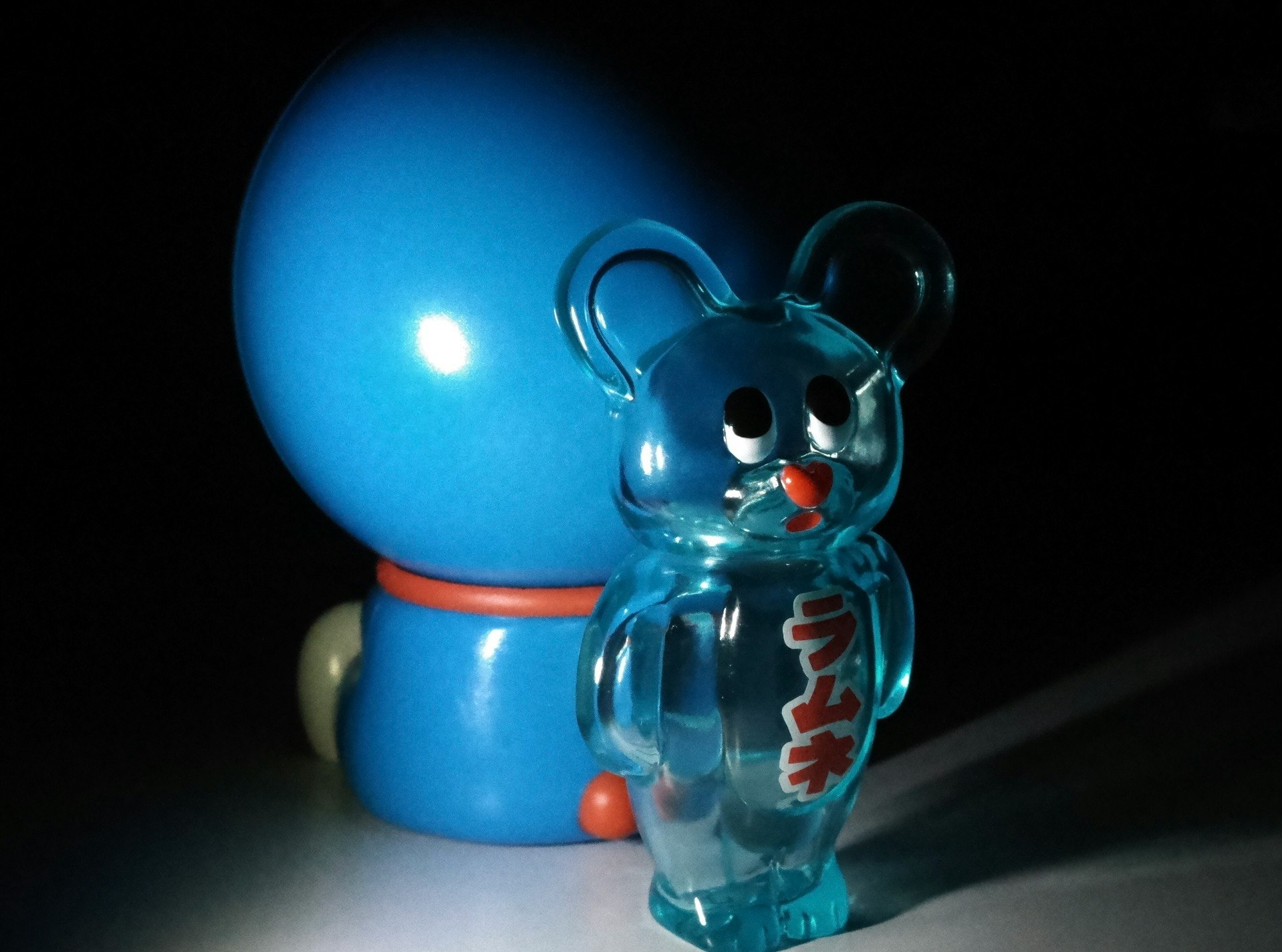 青いクマのガラス置物と丸いライトのある暗い室内