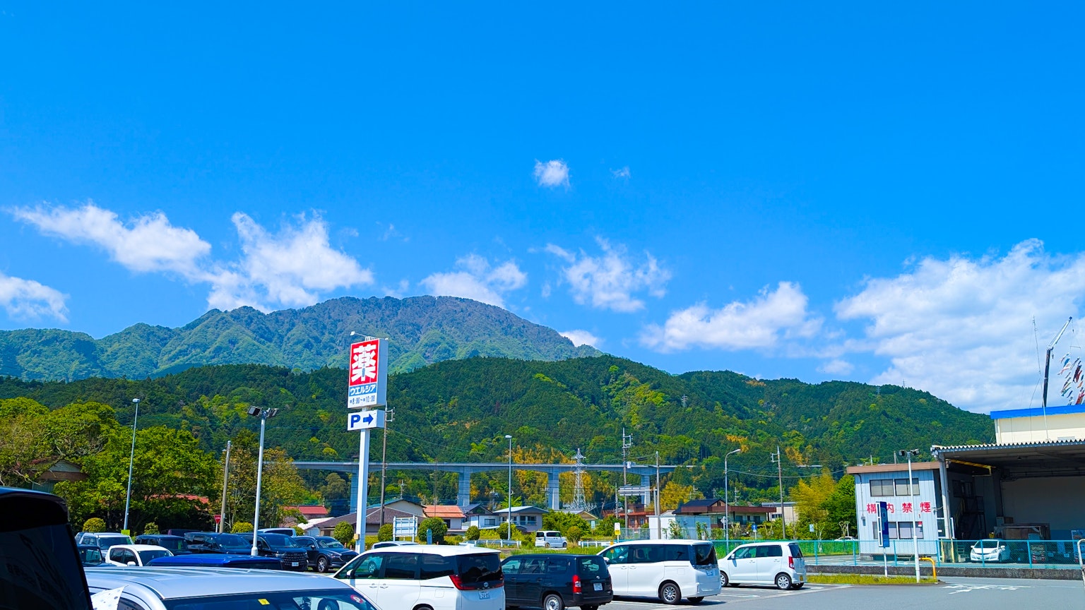 Scenic view of mountains under a blue sky with a parking lot in the foreground