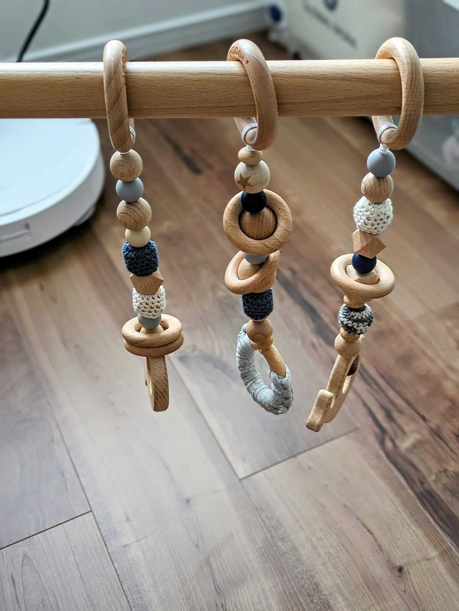 Set aus Holzringen und -perlen, die als Spielzeug für Babys an einem Gestell hängen