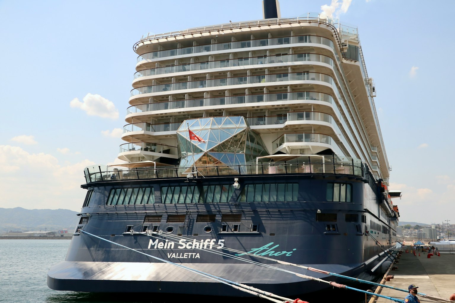 มุมมองด้านข้างของเรือสำราญหรู Mein Schiff 5 พร้อมทิวทัศน์ท่าเรือ