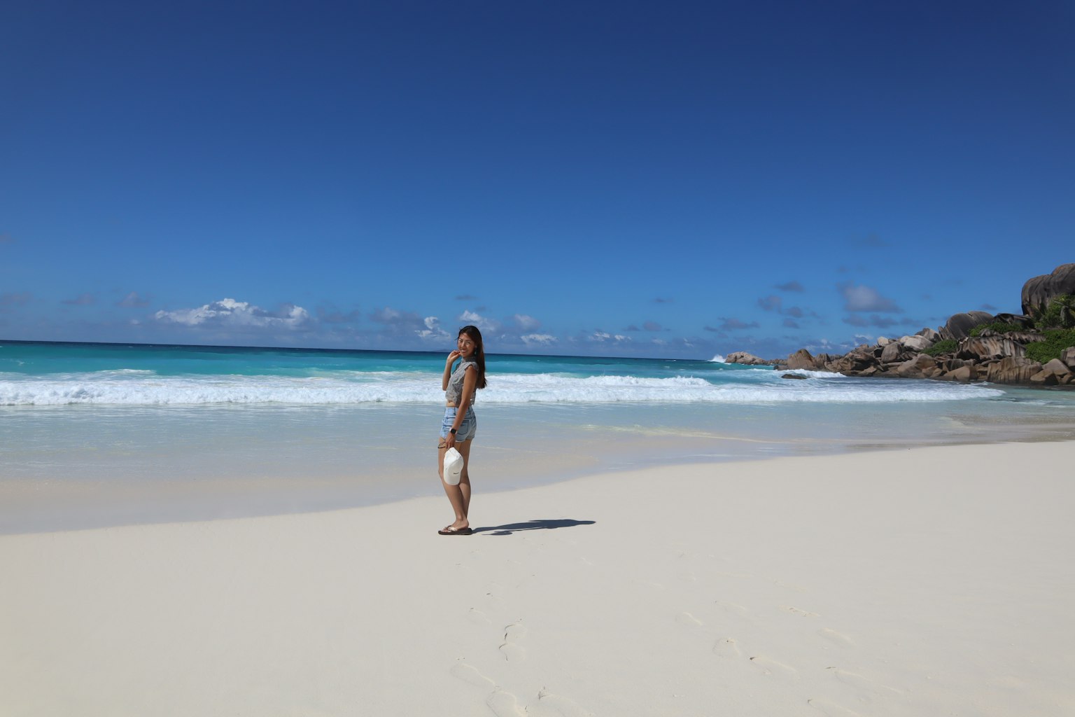 Une femme debout sur la plage avec un océan bleu