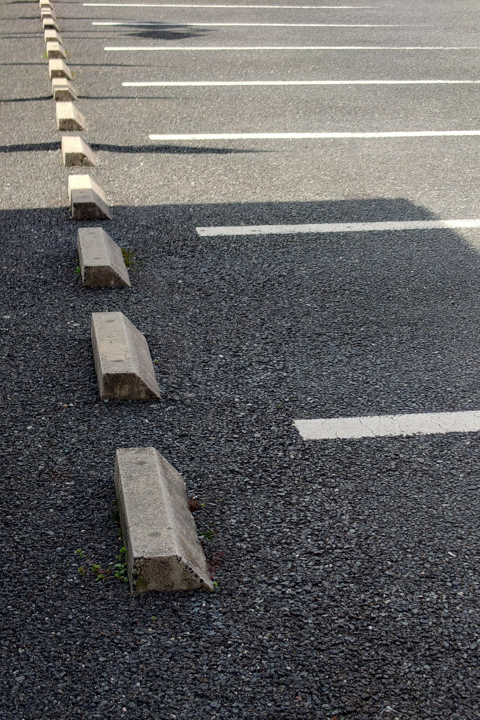 Terrain de stationnement en asphalte avec des barrières en béton et des lignes blanches