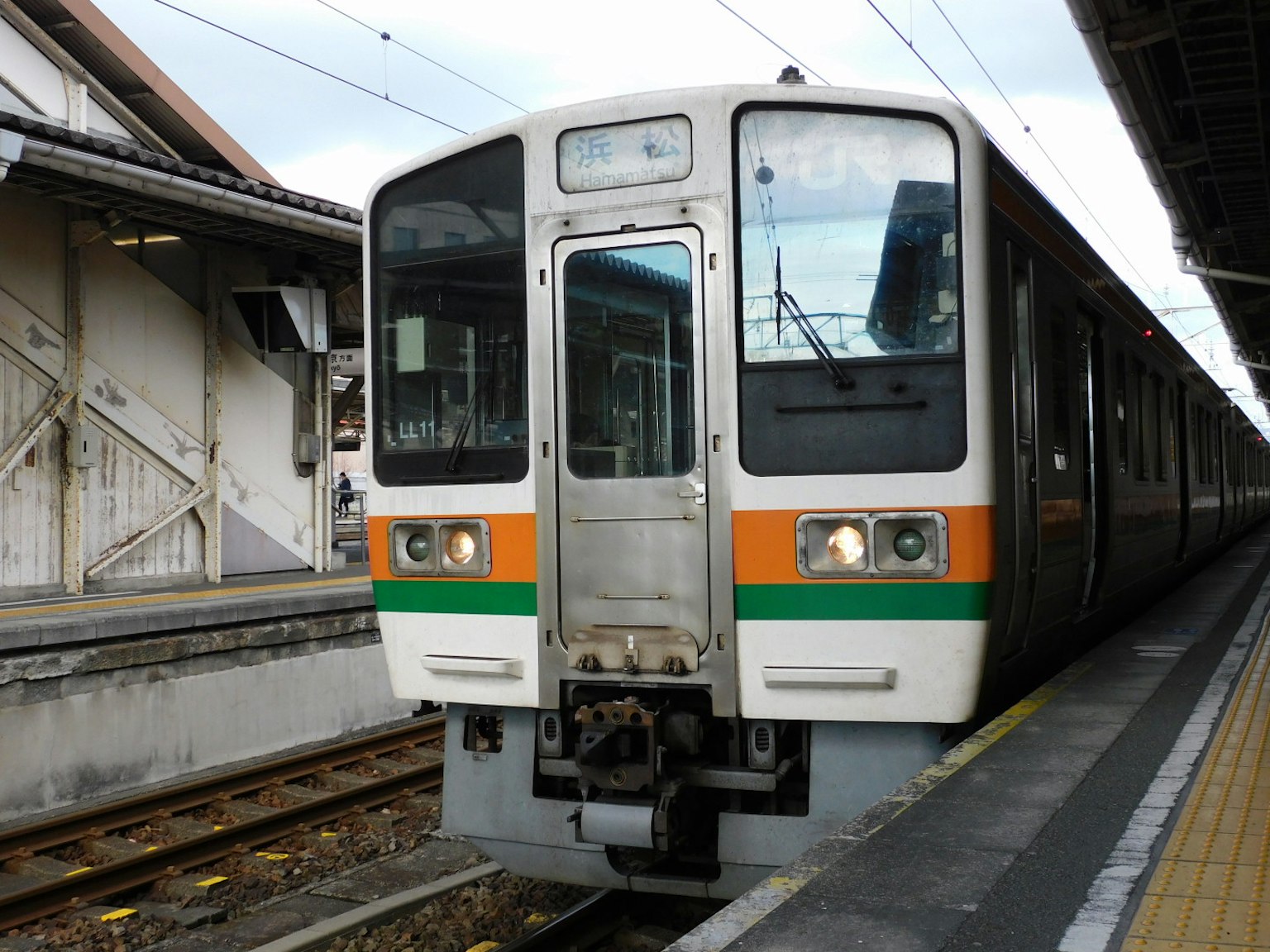 Treno con strisce arancioni e verdi fermo in stazione