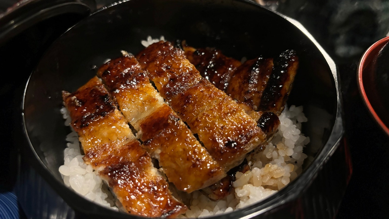 白米饭上放着烤鳗鱼的菜肴