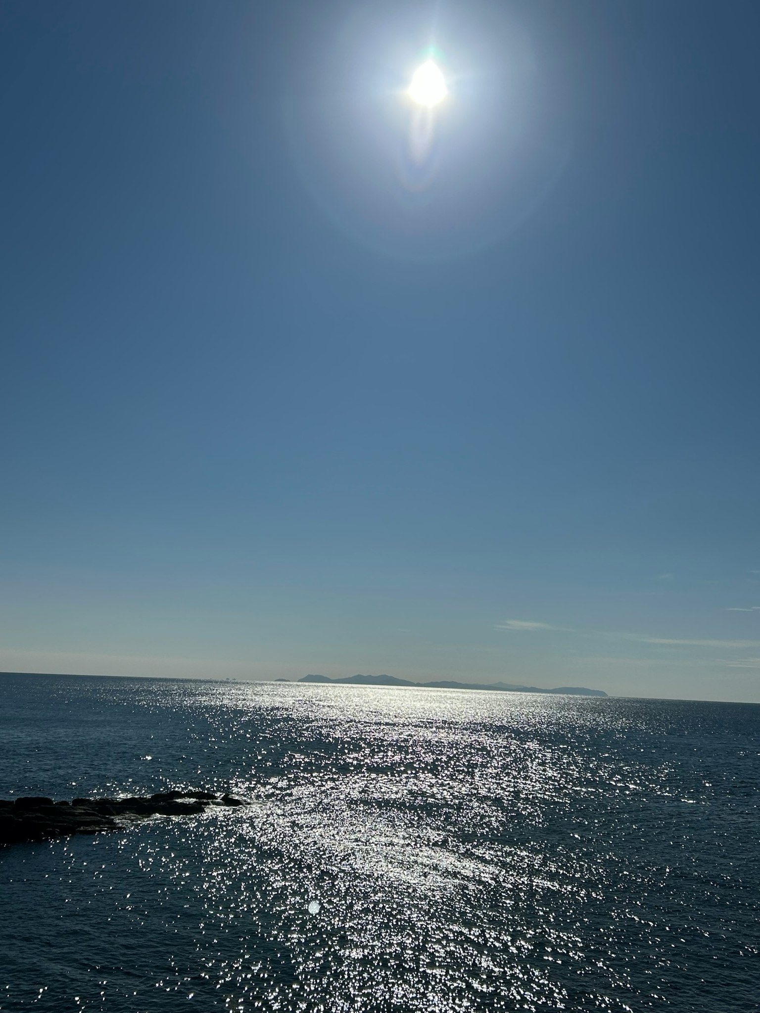 Un mar azul brillante con el sol reflejándose en el agua