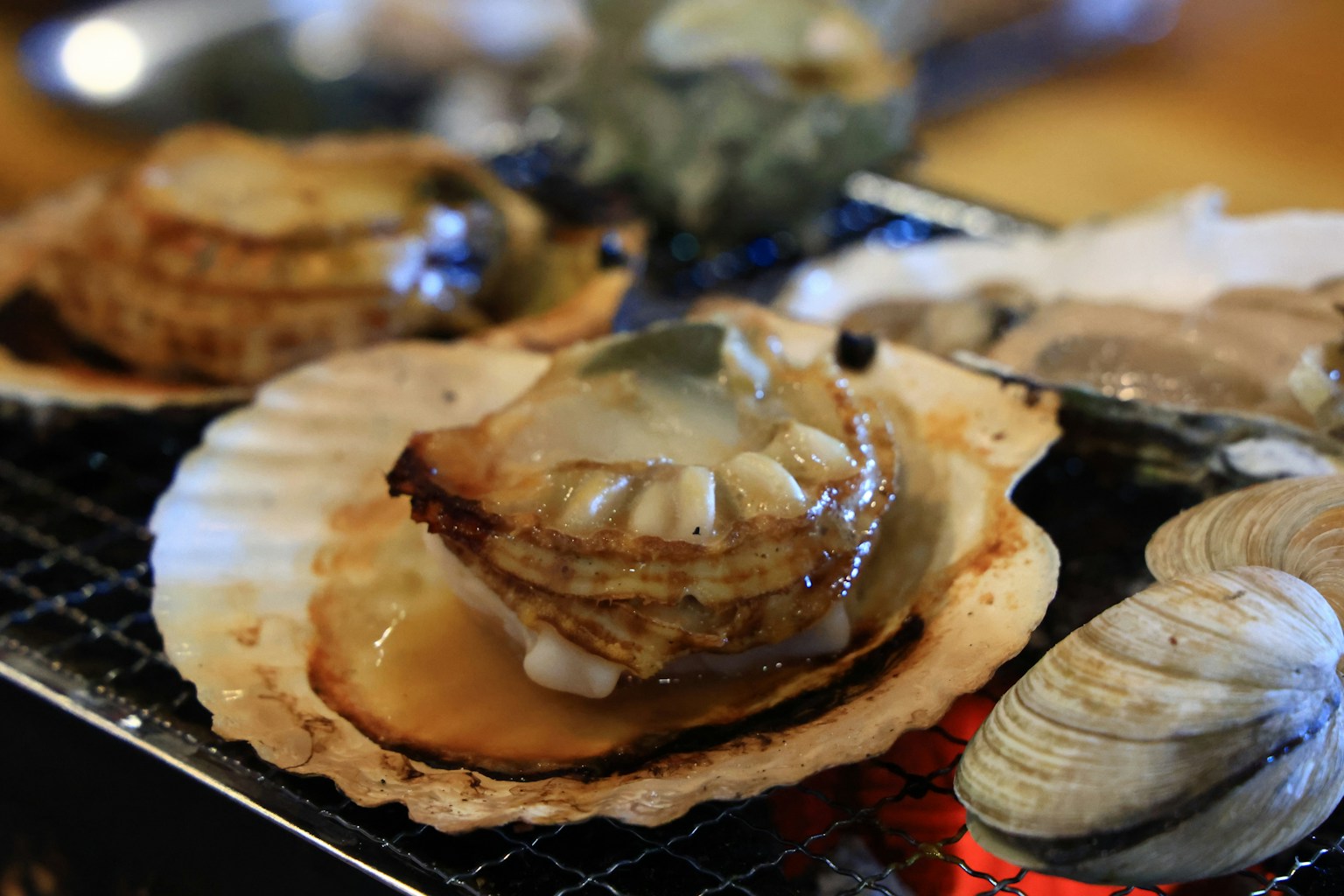 Gegrillte Schalentiere mit frischen Meeresfrüchten auf einer Jakobsmuschel