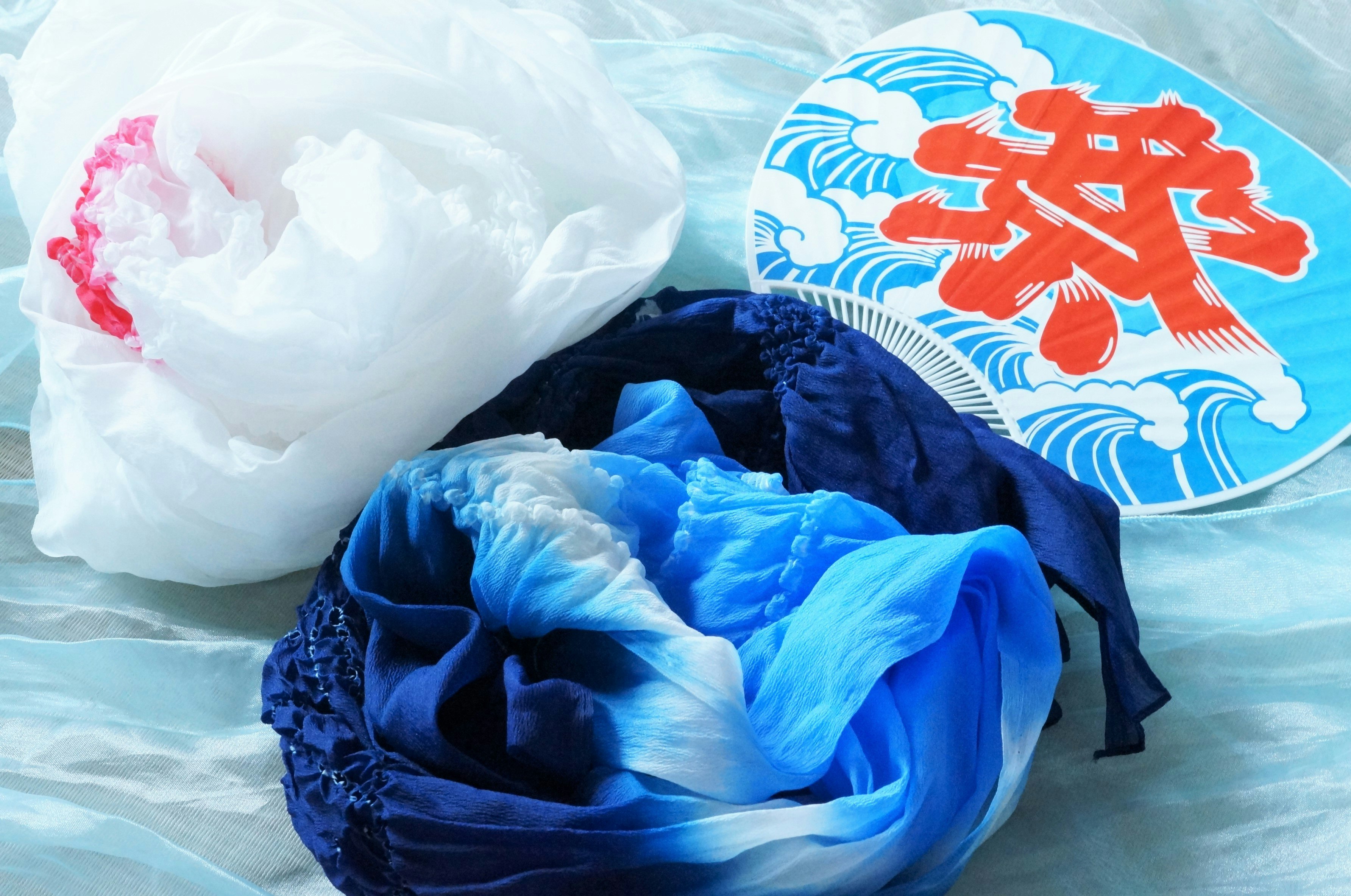 blue and white layered bedding with a red patterned towel
