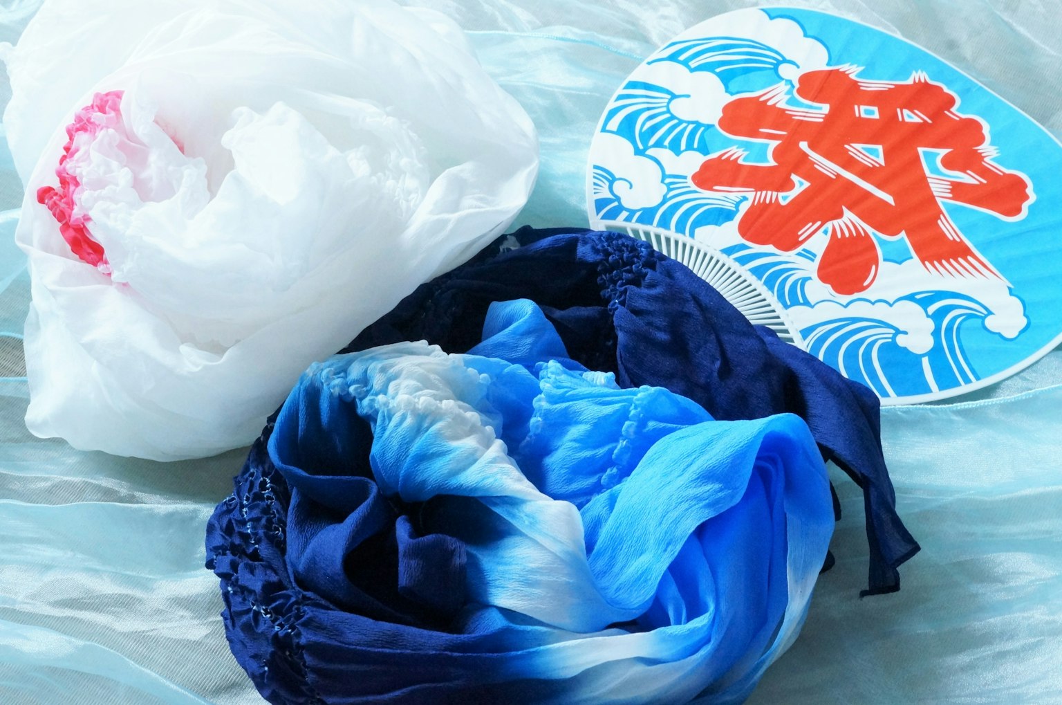 蓝色和白色的布料以及带有波浪图案的扇子