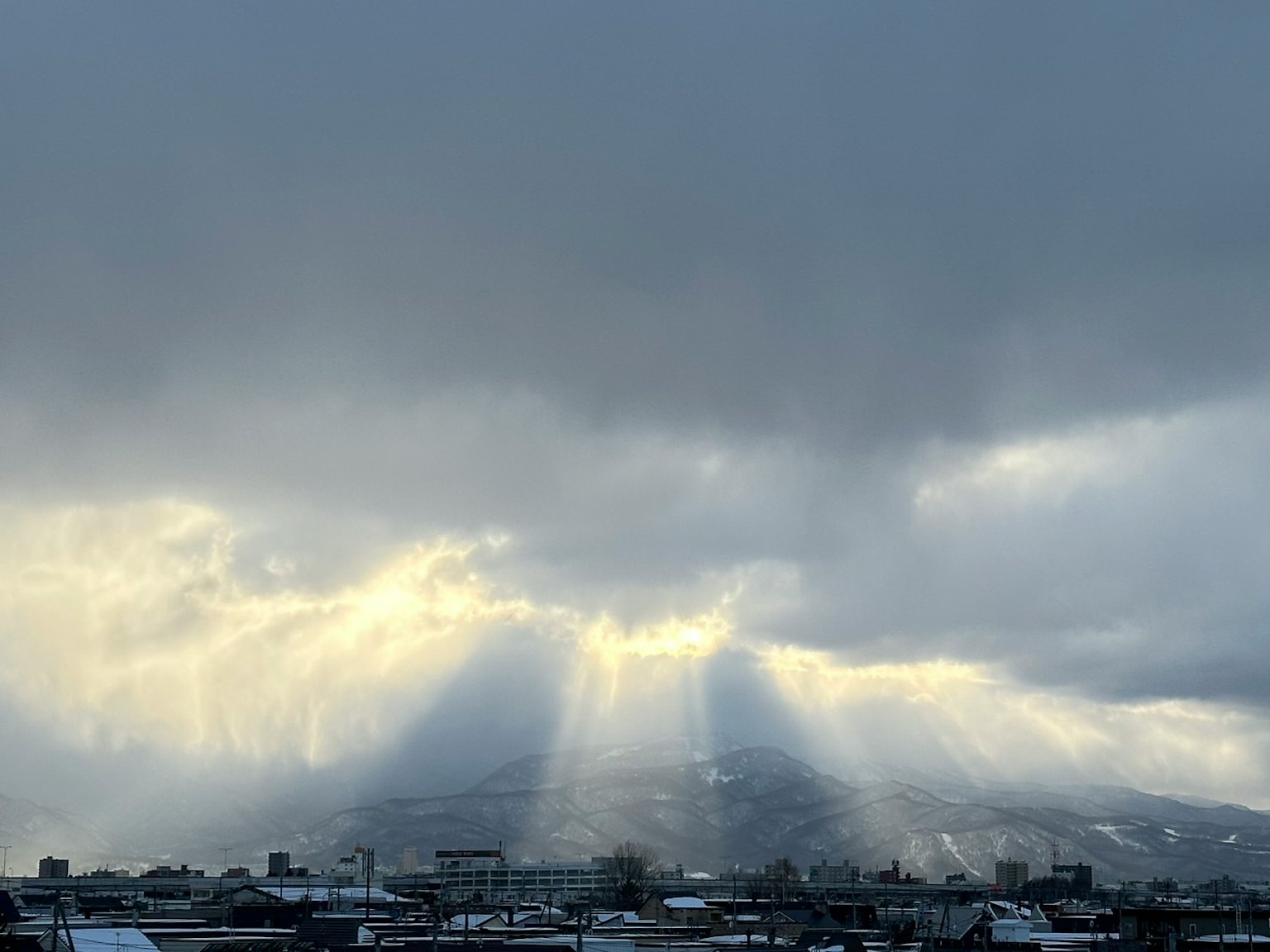 Rayos de luz atravesando nubes sobre montañas