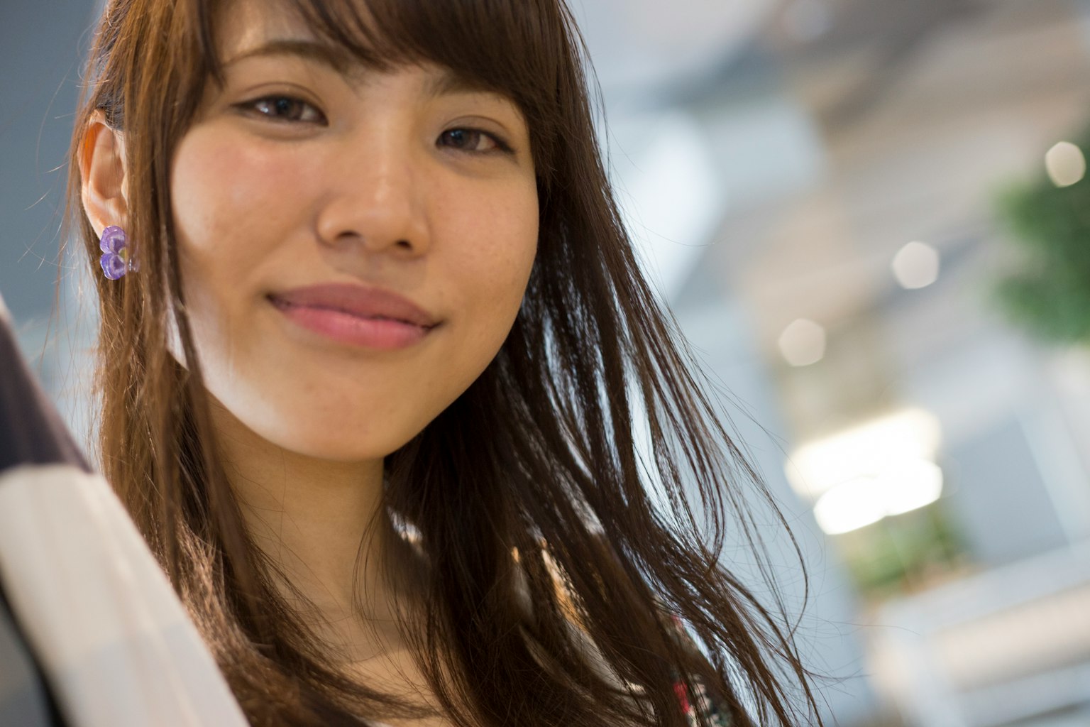 Portrait of a smiling woman with long hair in a bright background