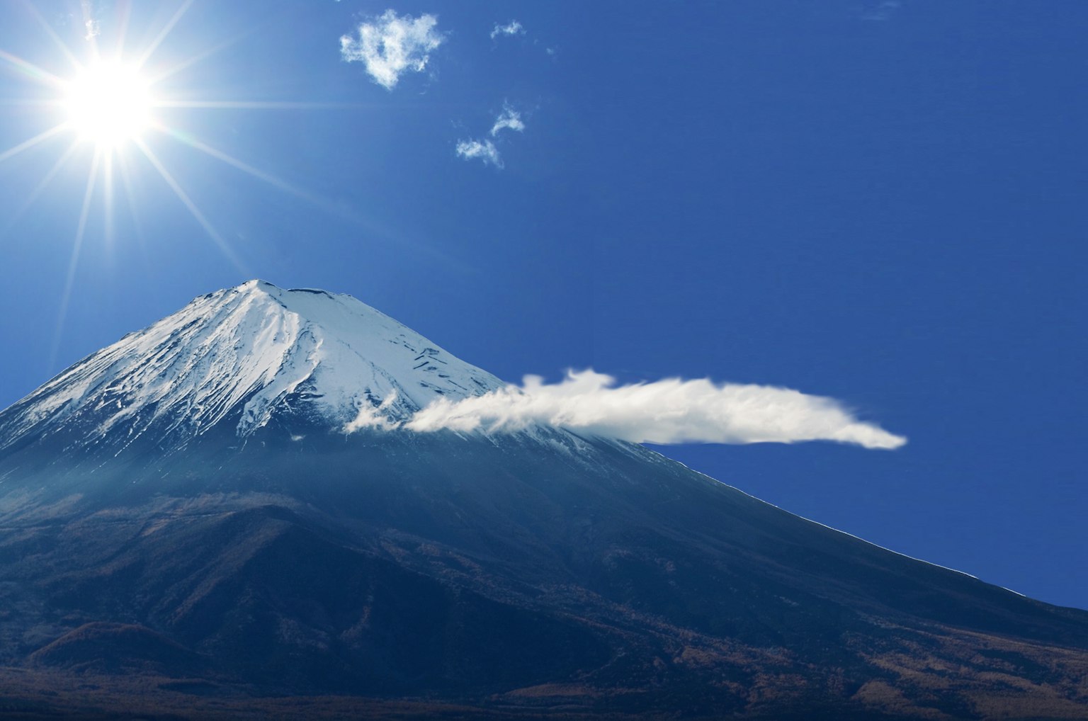 Monte Fuji che si erge maestoso sotto un cielo blu limpido con un sole splendente