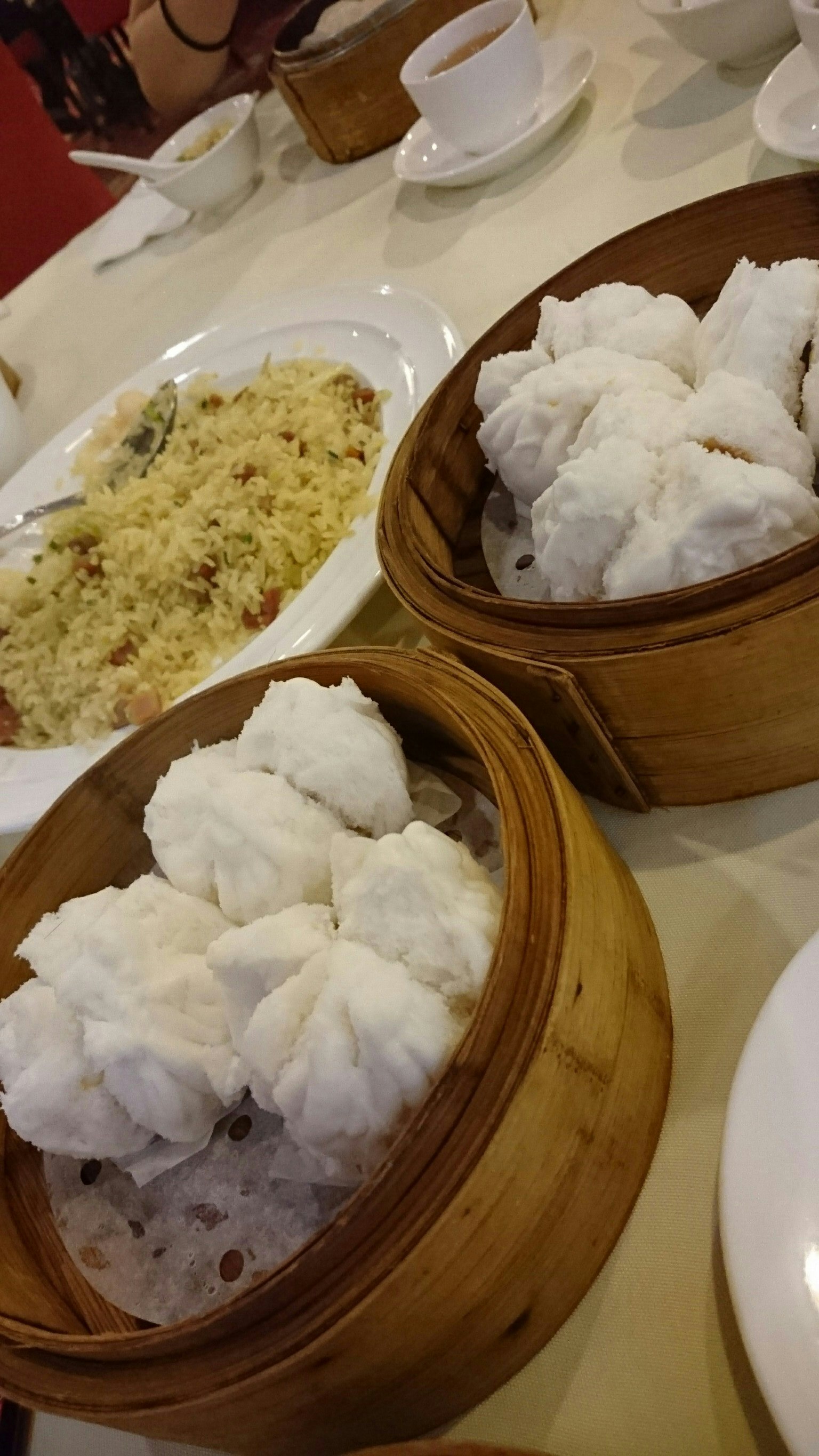 竹蒸笼里装满了饺子和炒饭的桌子