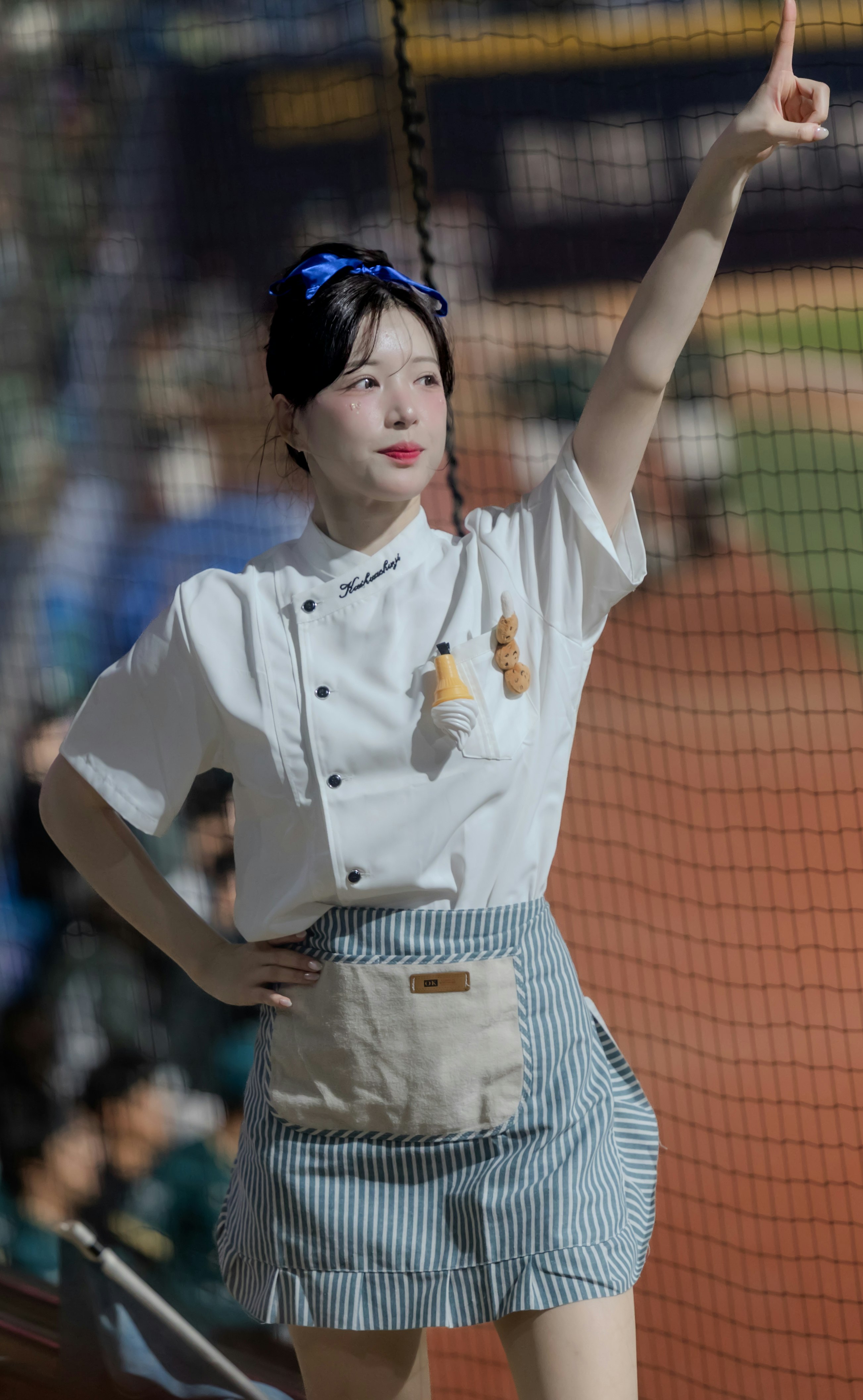 野球場で腕を上げる制服姿の女性