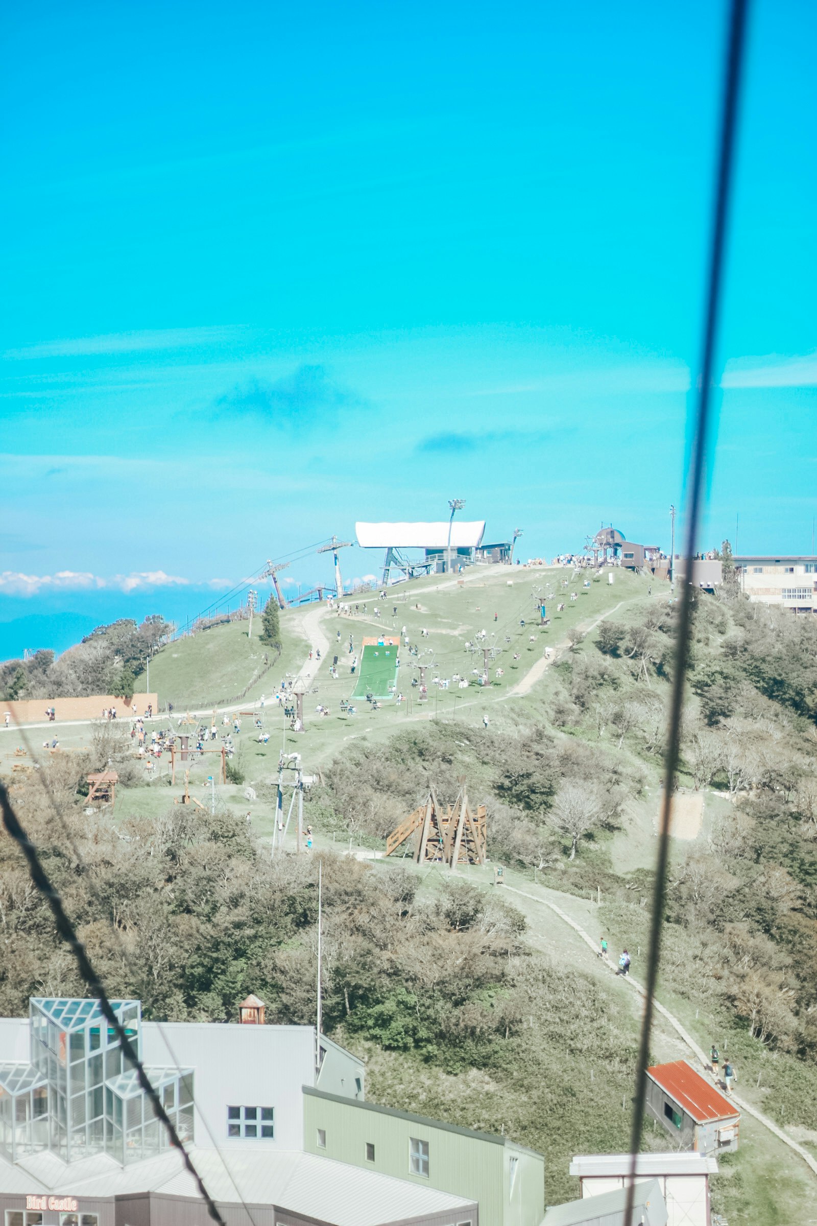 丘の上に広がる風力発電と展望台のある山道の景色