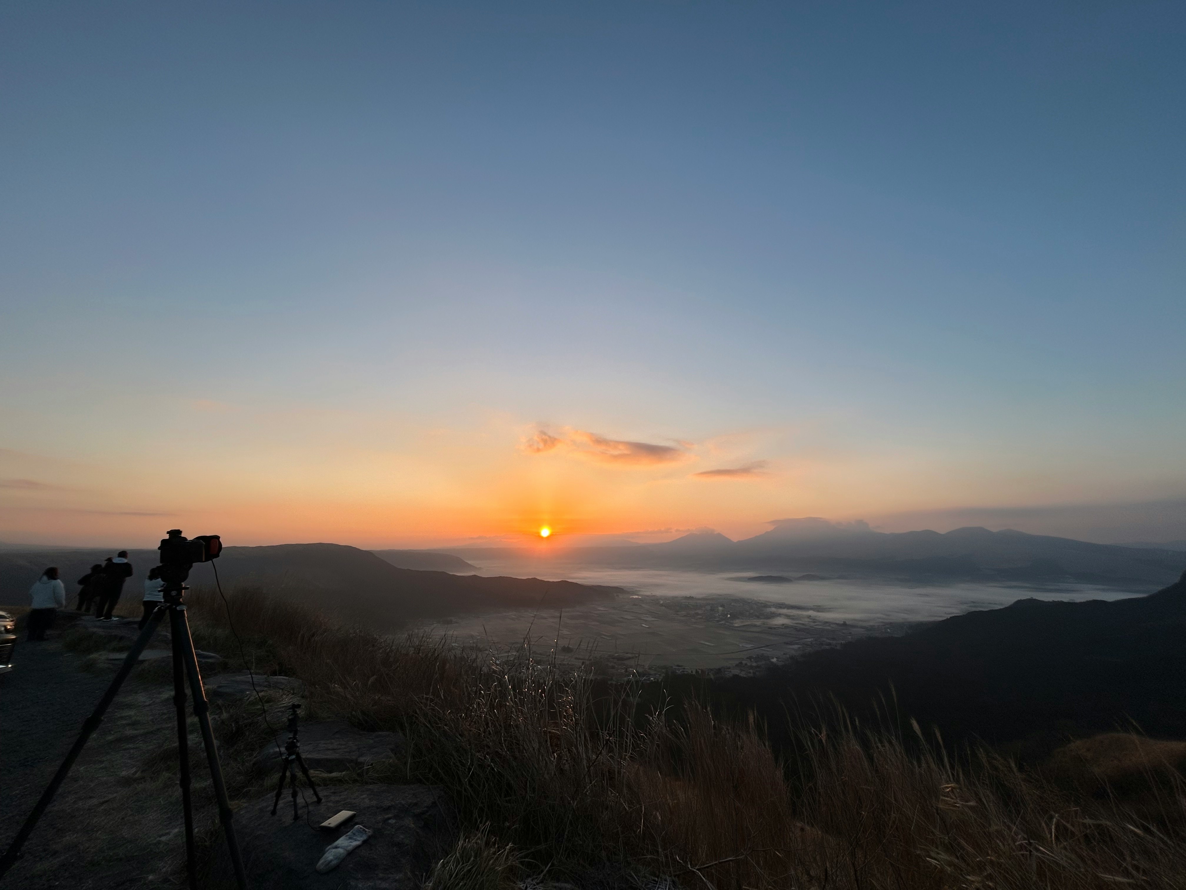冬の海を望む霧のかかった丘の夕景