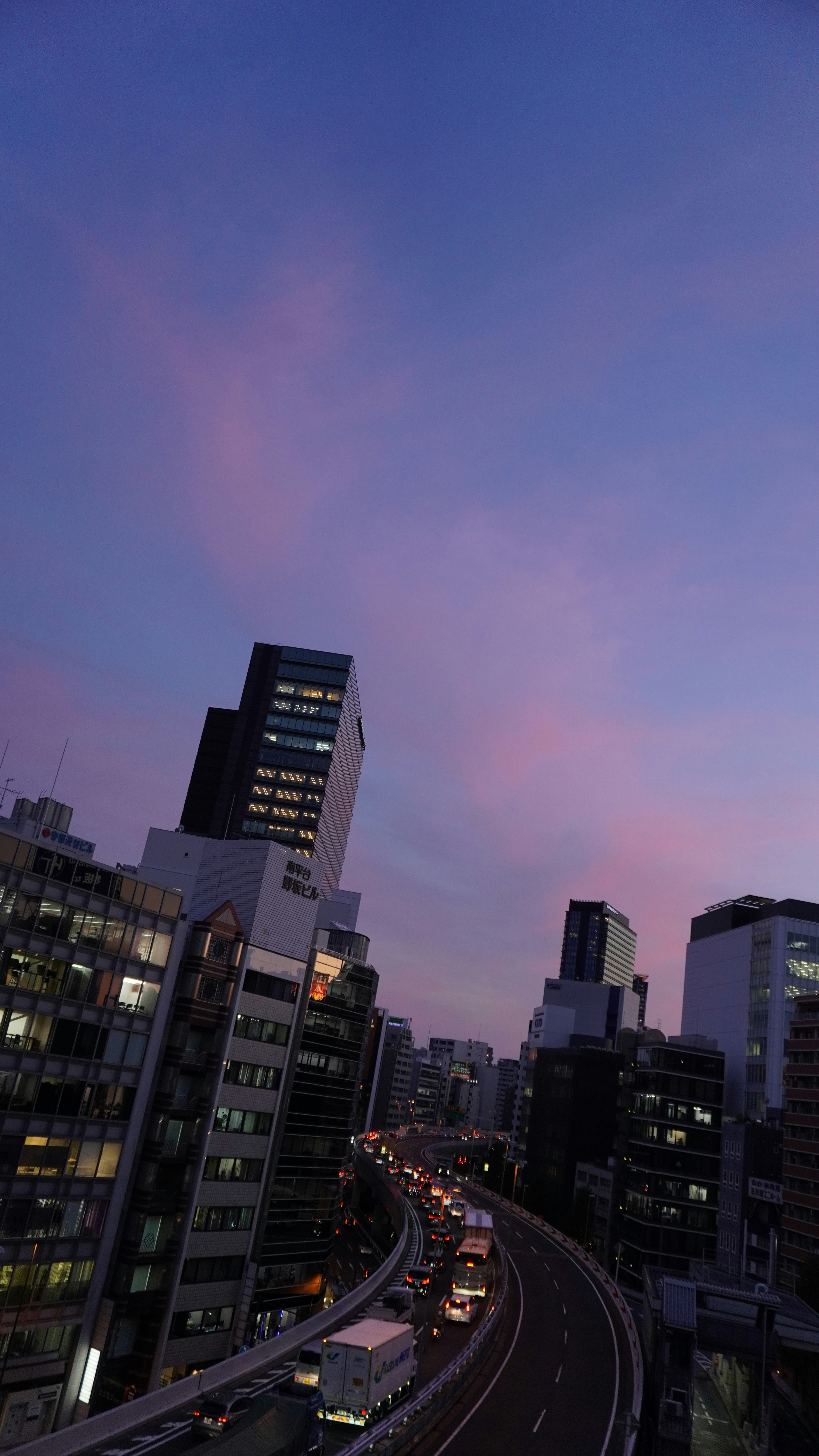 夕暮れの高架道路とビル群の夜景
