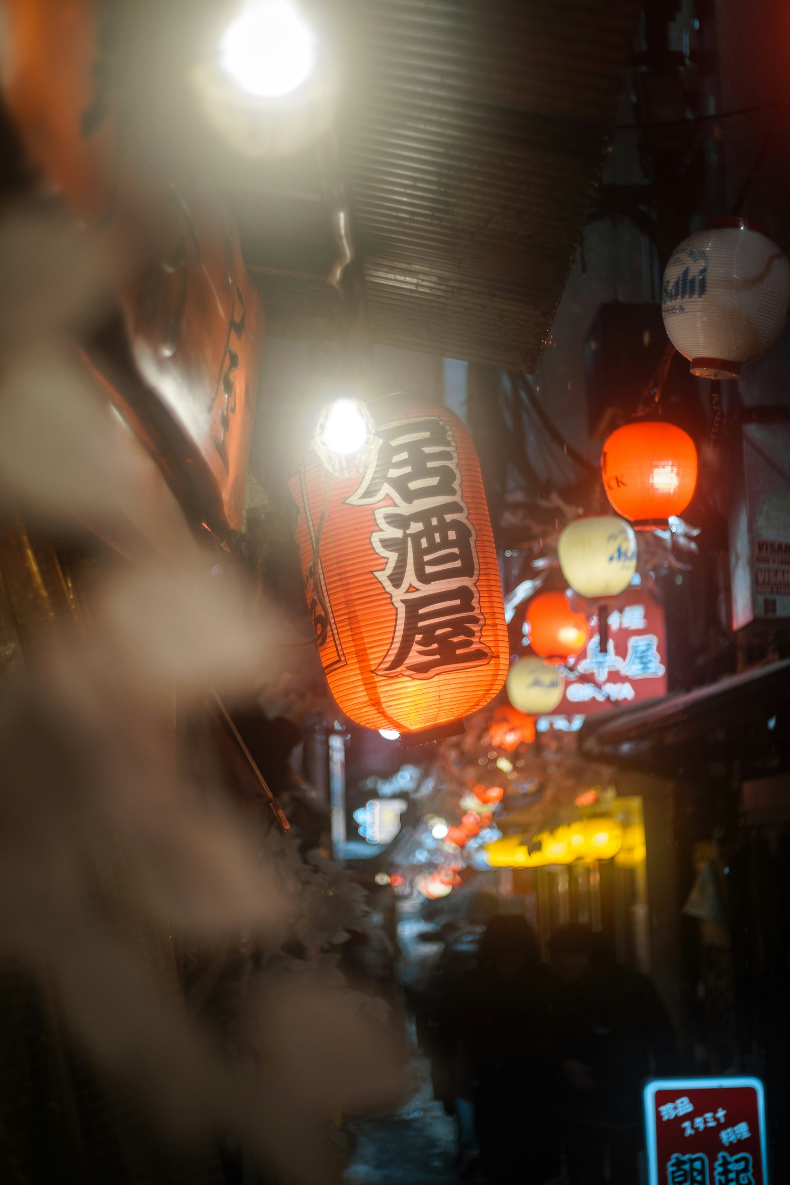 狹窄巷道的夜景，燈籠和霓虹燈