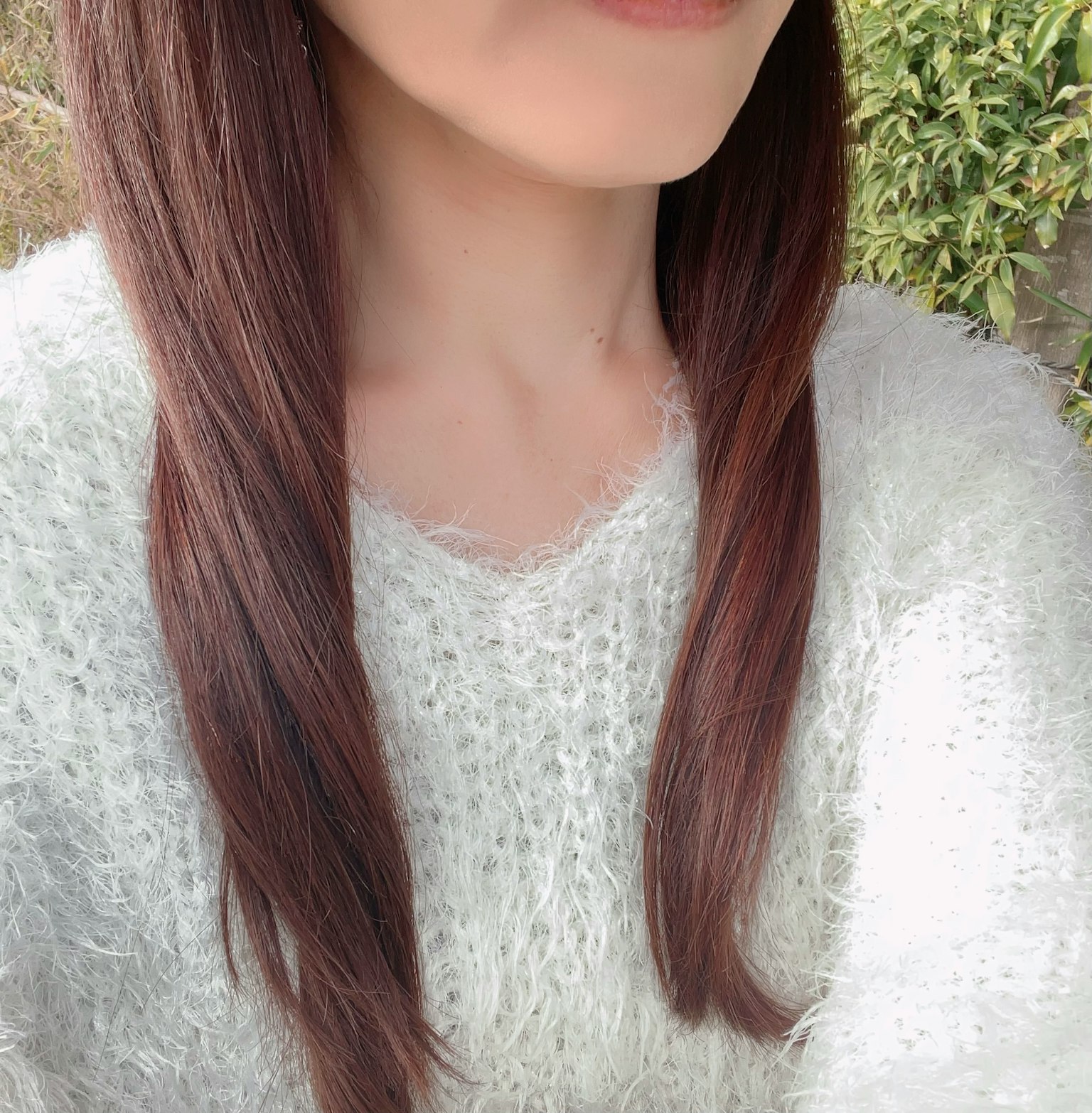 一位穿着蓬松白色毛衣的女性特写，长棕色头发