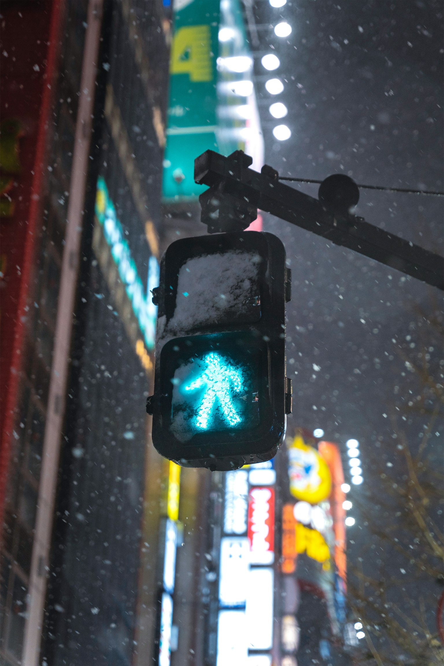 夜晚城市景觀中閃爍的綠色行人信號燈