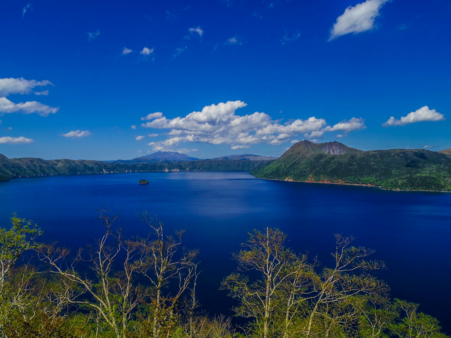 Vue panoramique d'un lac bleu entouré de montagnes