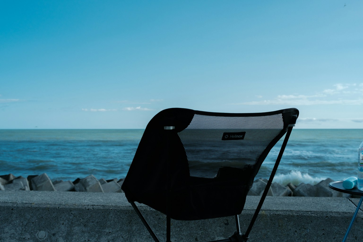 Chaise noire avec vue sur la mer et le ciel bleus