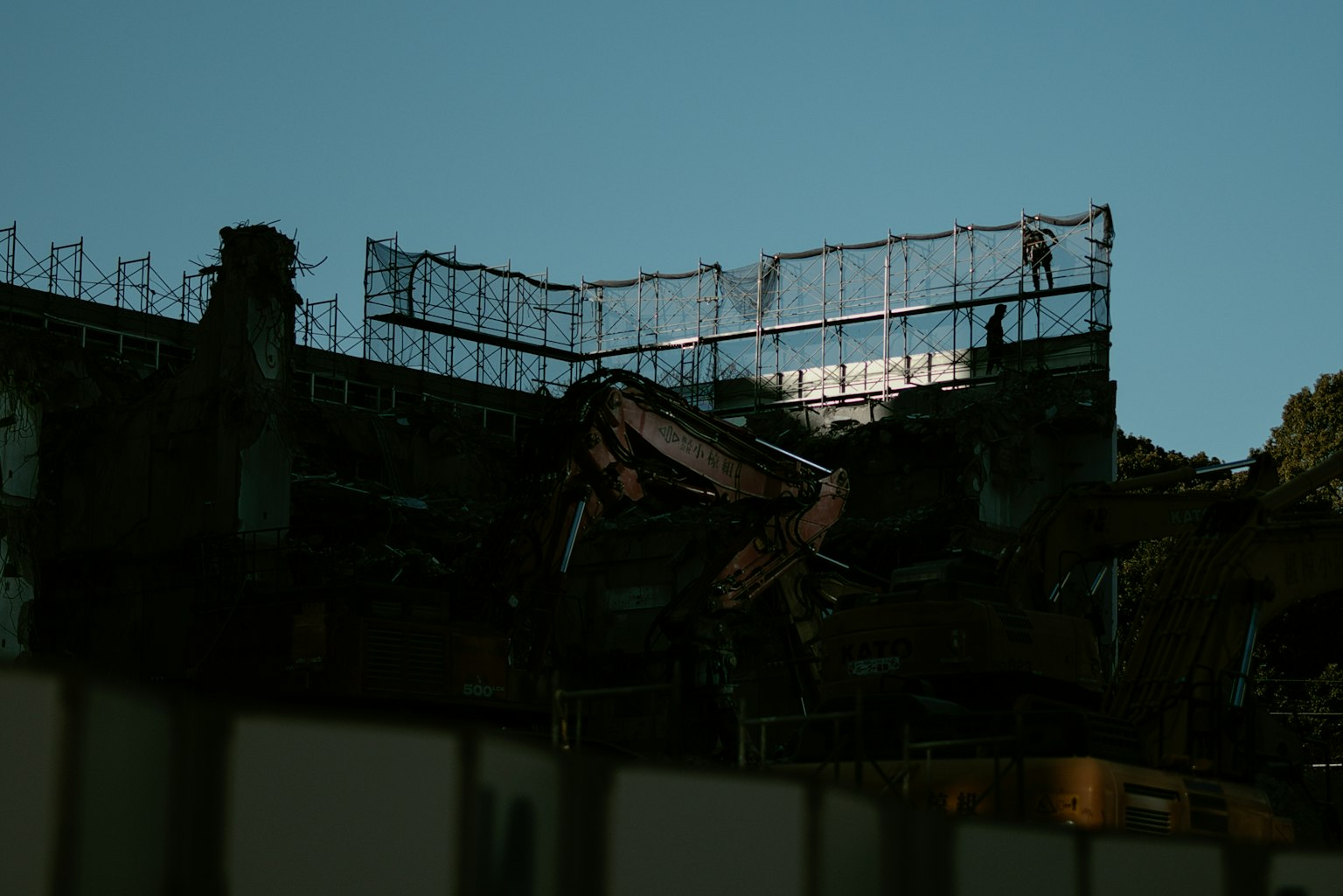 Vista serale di un cantiere con una gru e un'impalcatura