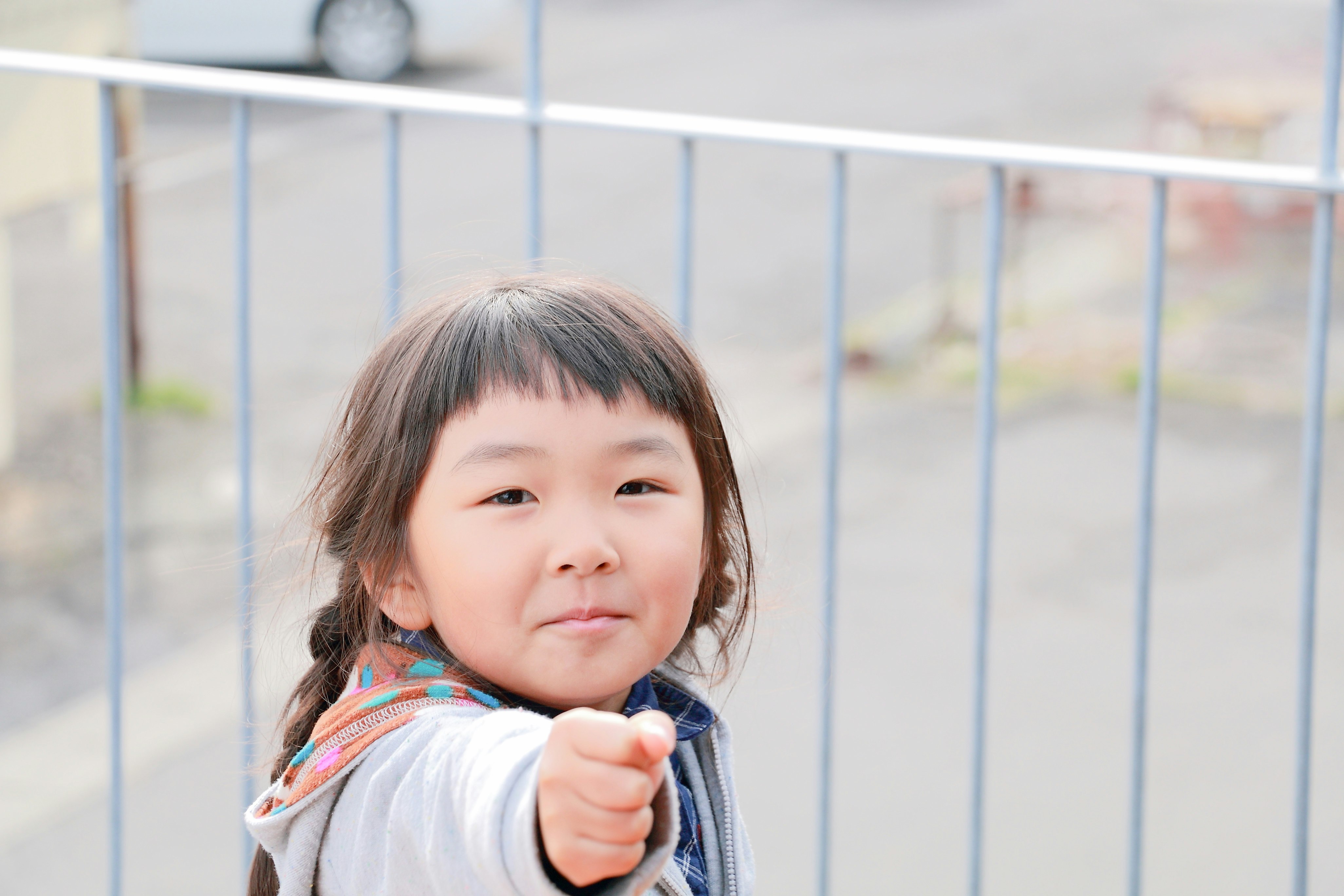 Portrait of a smiling child in front of a fence