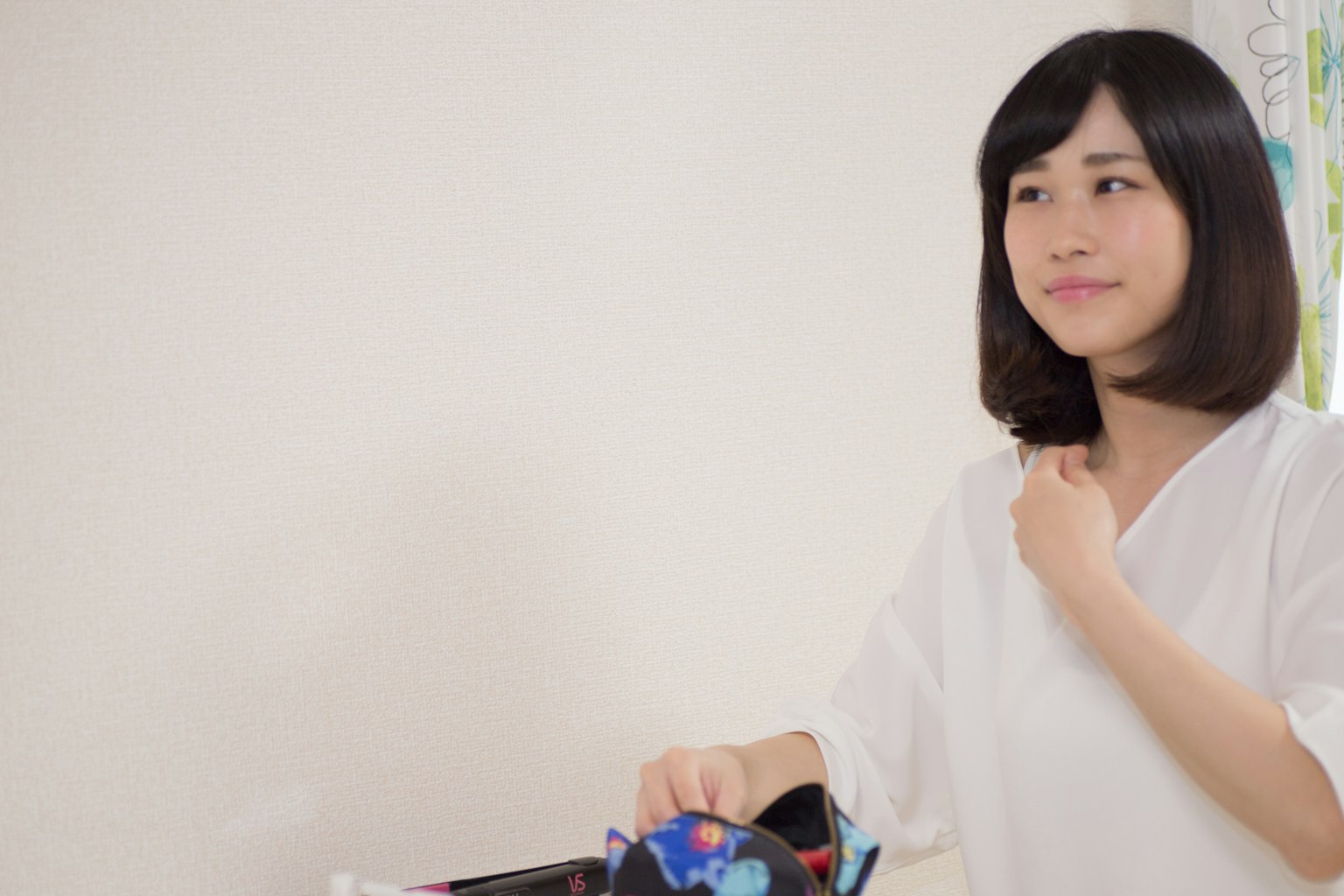 一位穿著白襯衫的女性在室內微笑