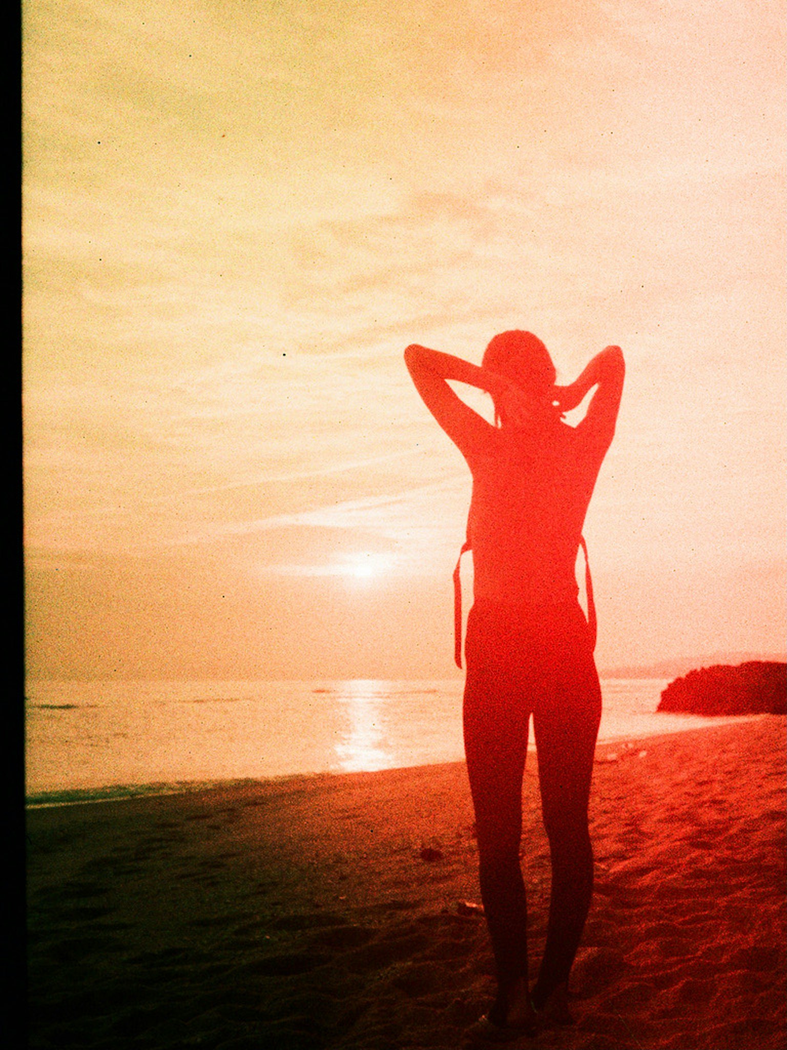 Silueta de una mujer contra un atardecer en la playa