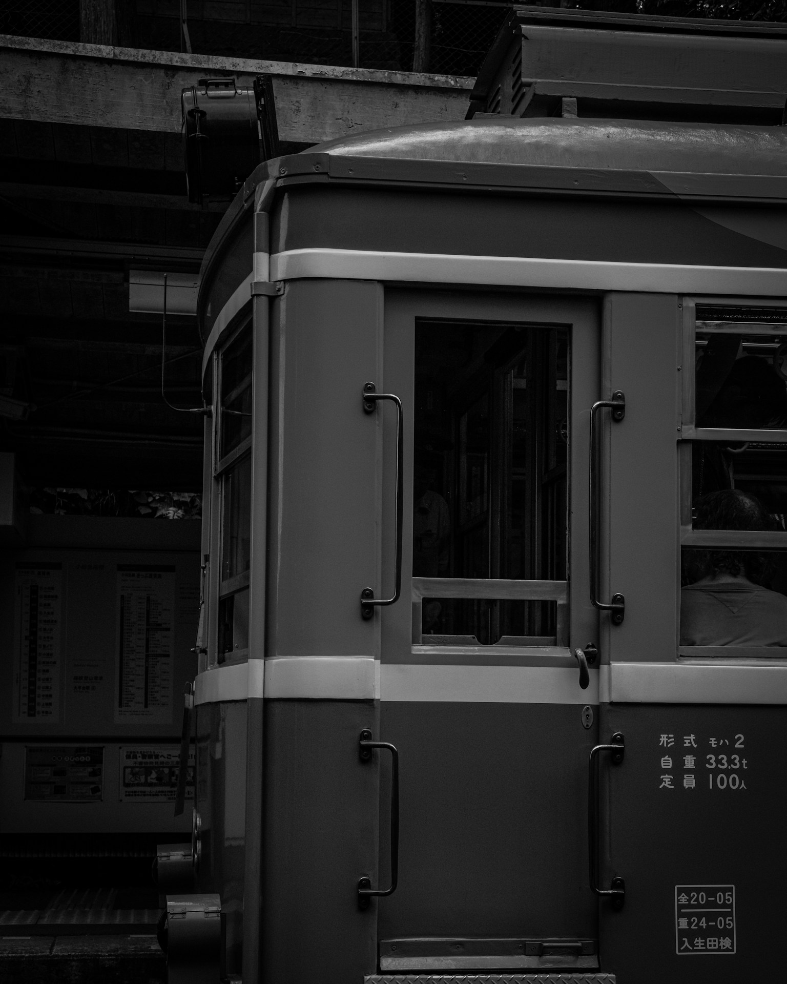 Close-up of an old train's side and window details in black and white