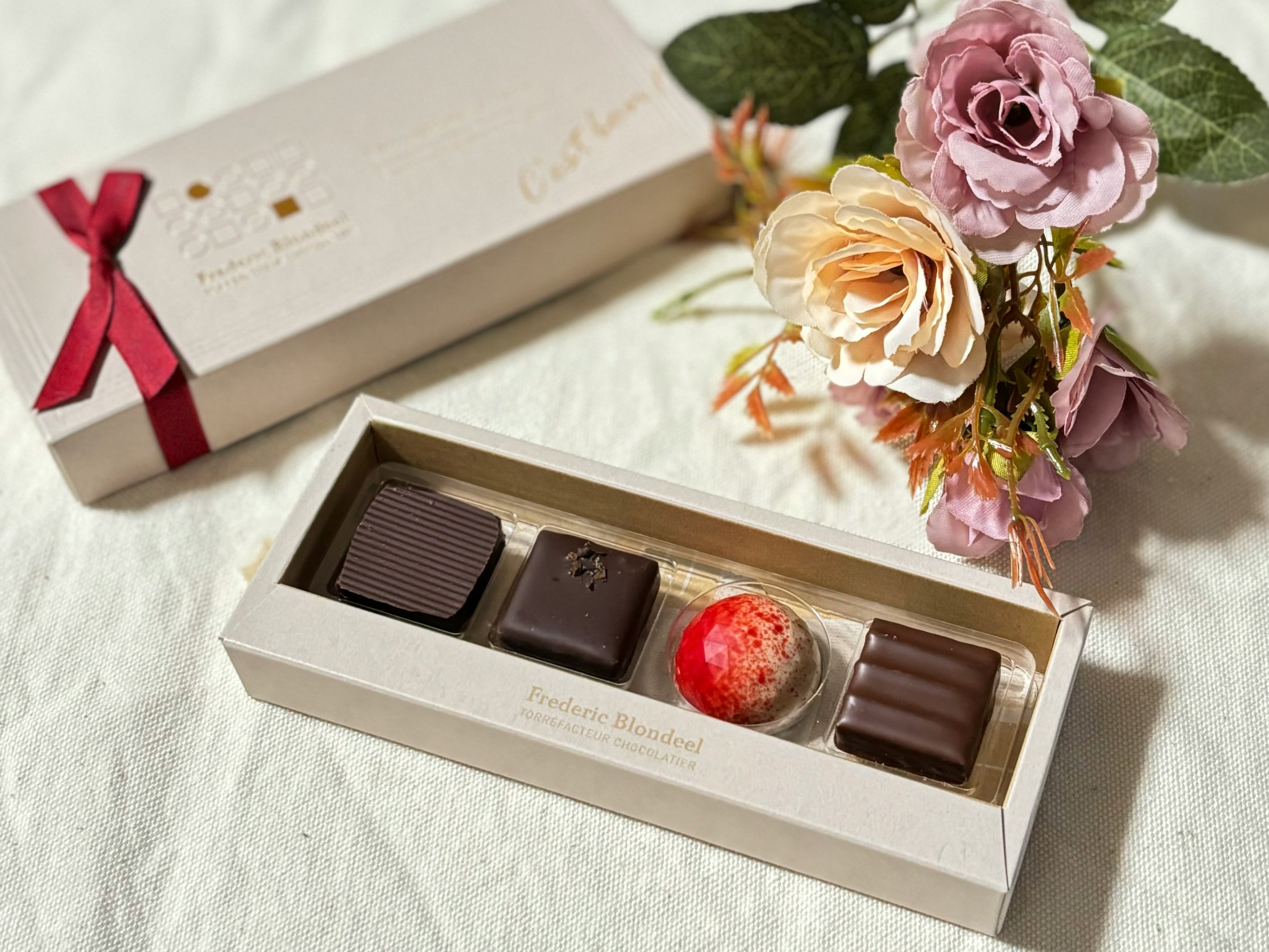 Geschenkschachtel mit Pralinen und Blumen