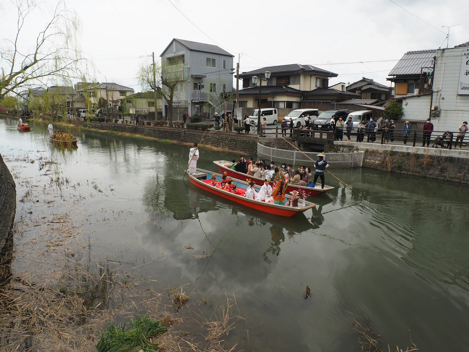 Orang-orang di perahu wisata di sungai yang dikelilingi rumah