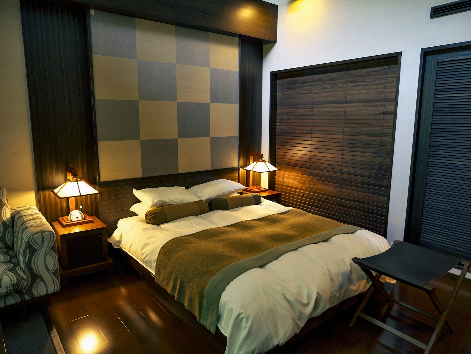 Dormitorio moderno con diseño simple que presenta un cabecero a cuadros en varios colores iluminación moderna y muebles de madera
