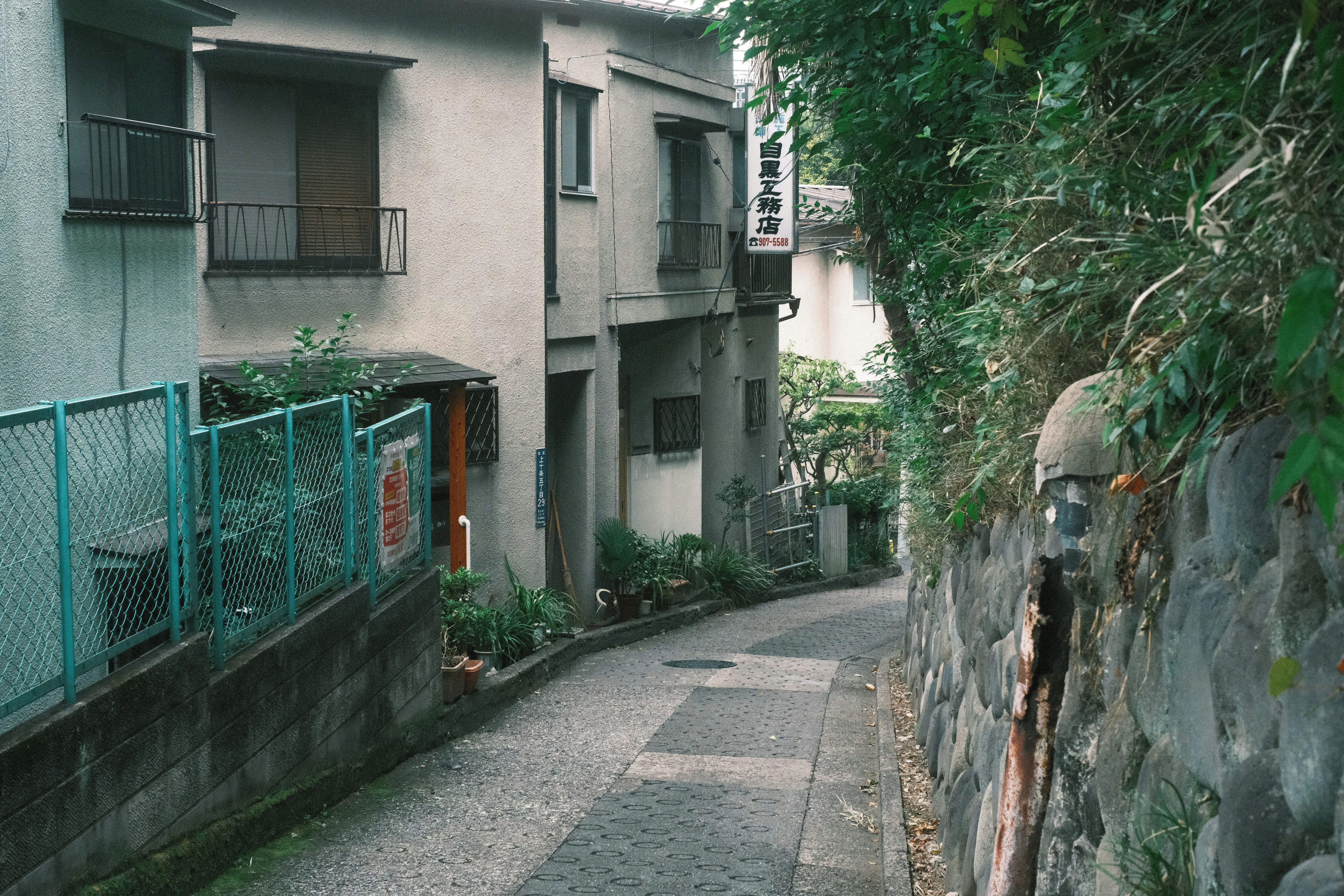ruelle étroite bordée d’immeubles et d’un mur de soutènement en pierre