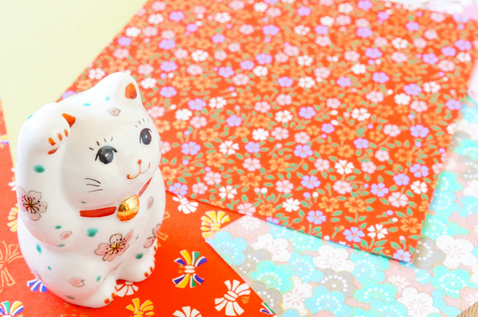 Một bức tượng mèo may mắn trắng trên giấy washi có hoa văn sống động