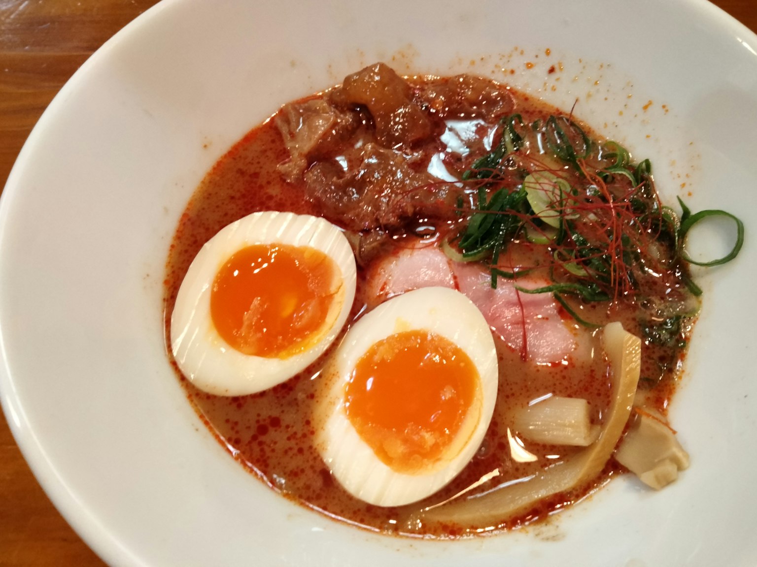 Schüssel Ramen mit weichgekochten Eiern Scheiben von Chashu und Frühlingszwiebeln in Brühe
